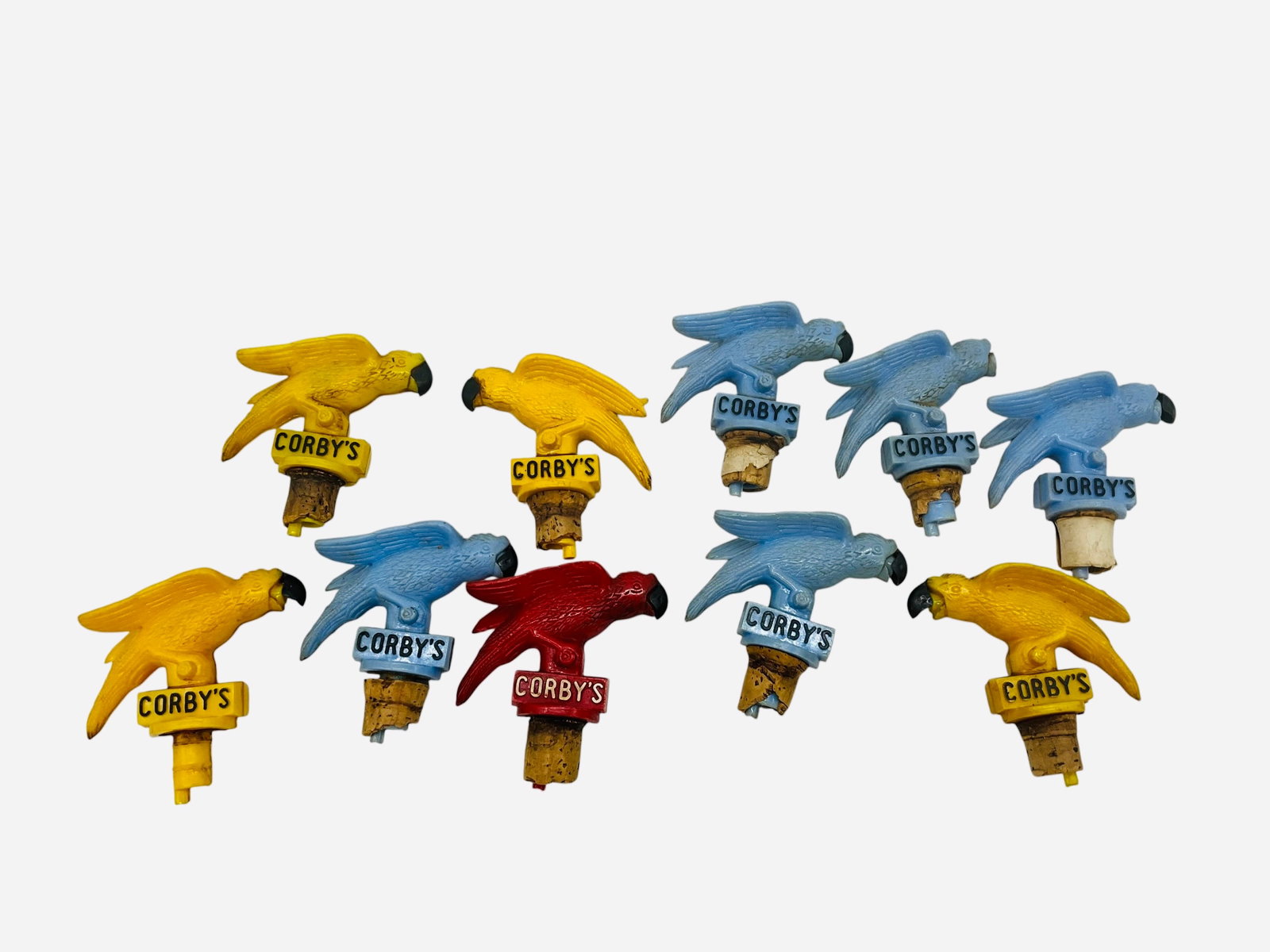 Ten Corby's Parrot Liquor Bottle Pourers: A nice collection of vintage Corby's bottle pourers and stoppers. Ten total. Five blue, four yellow and one red. One blue stopper is missing beak. Other nine in great condition.