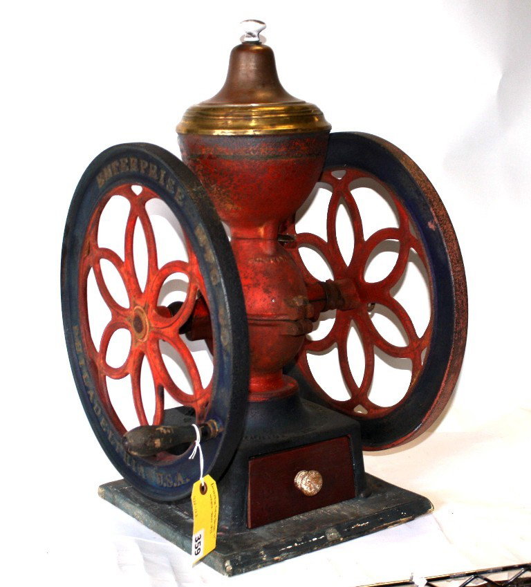 ENTERPRISE COFFEE GRINDER: ENTERPRISE COFFEE GRINDER WITH 17'' DBL WHEELS AND DATED 1873, measuring 26" to the top crest of the machine, wheels measure 17" diameter and 18" from wheel to end of handle across, weight approx 40-5