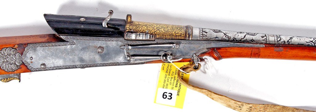 INDIAN MATCHLOCK CARBINE: INDIAN MATCHLOCK CARBINE WITH HEAVY ENGRAVED BARREL WITH ELEPHANTS AND TIGERS, 2'' BARREL TIP IS TIGER IN FULL RELIEF, HEAVY GOLD DECORATIONS. CONDITION MINOR BEND ON RIGHT SIDE PLATE WITH SLIGHT WOOD