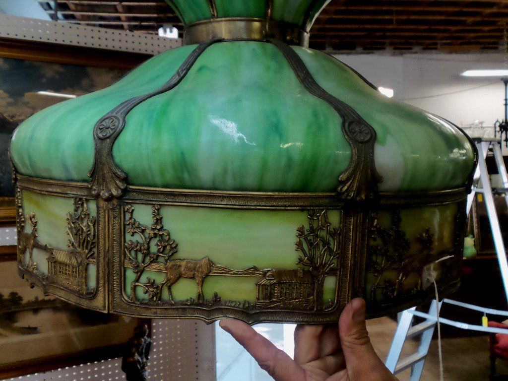 STAINED GLASS LAMP: GREEN STAINED GLASS HANGING LAMP WITH ELK METAL FRAME, CONDITION IS GOOD GLASS IS INTACT AND NOT CRACKED, ONE ELK'S HEAD HAS BROKEN OFF METAL FRAME AND THERE IS A COIN SIZE AREA ON THE FRINGE THAT APP