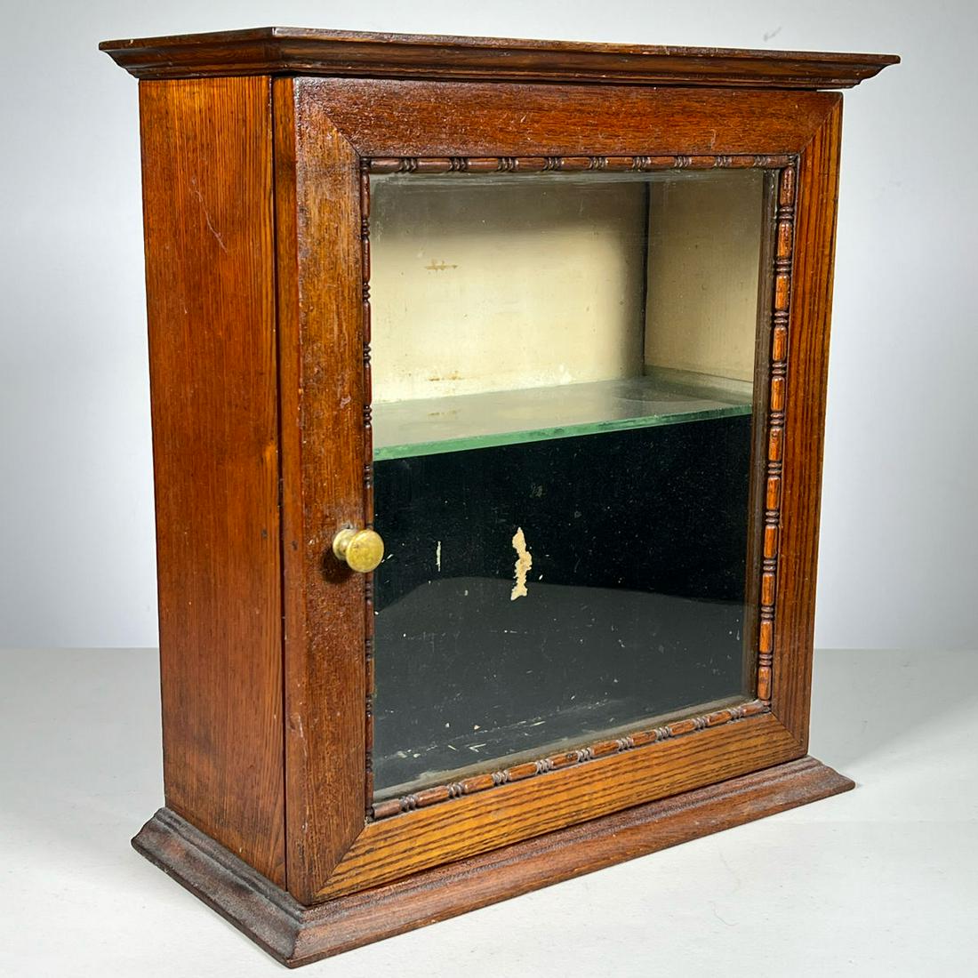 OAK DISPLAY CABINET: Cabinet with front glass door and one glass shelf. Turned molding around glass. Inventory Code: 1K-96 Provenance: Part of over six-hundred Items consigned from an important Millwood, NY family
