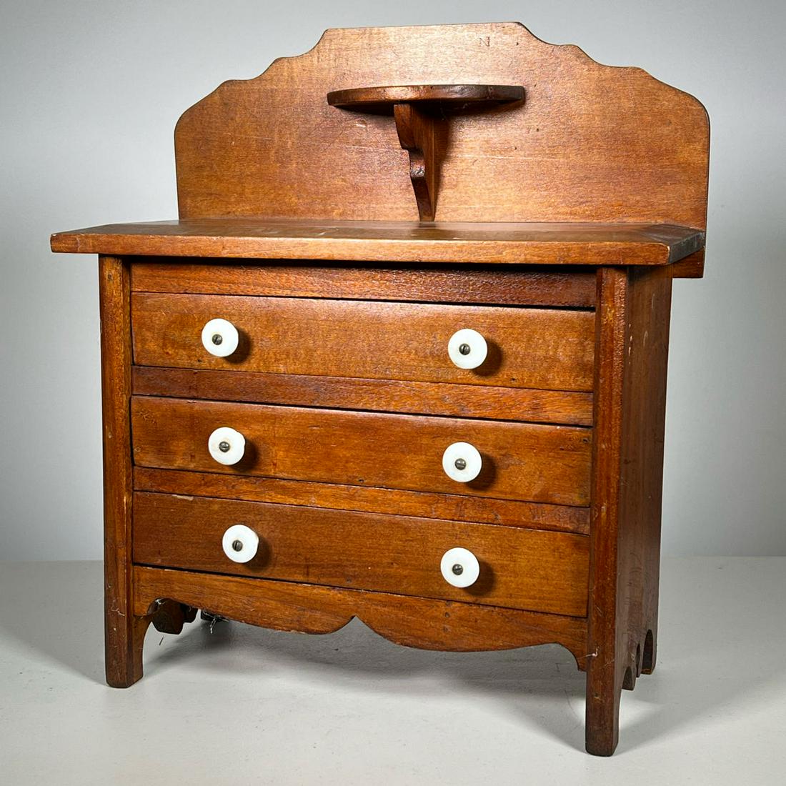 MINIATURE CHEST WITH BACKSPLASH: Chest with three drawers. Backsplash has candle stand. Inventory Code: 1K-115 Provenance: Part of over six-hundred Items consigned from an important Millwood, NY family