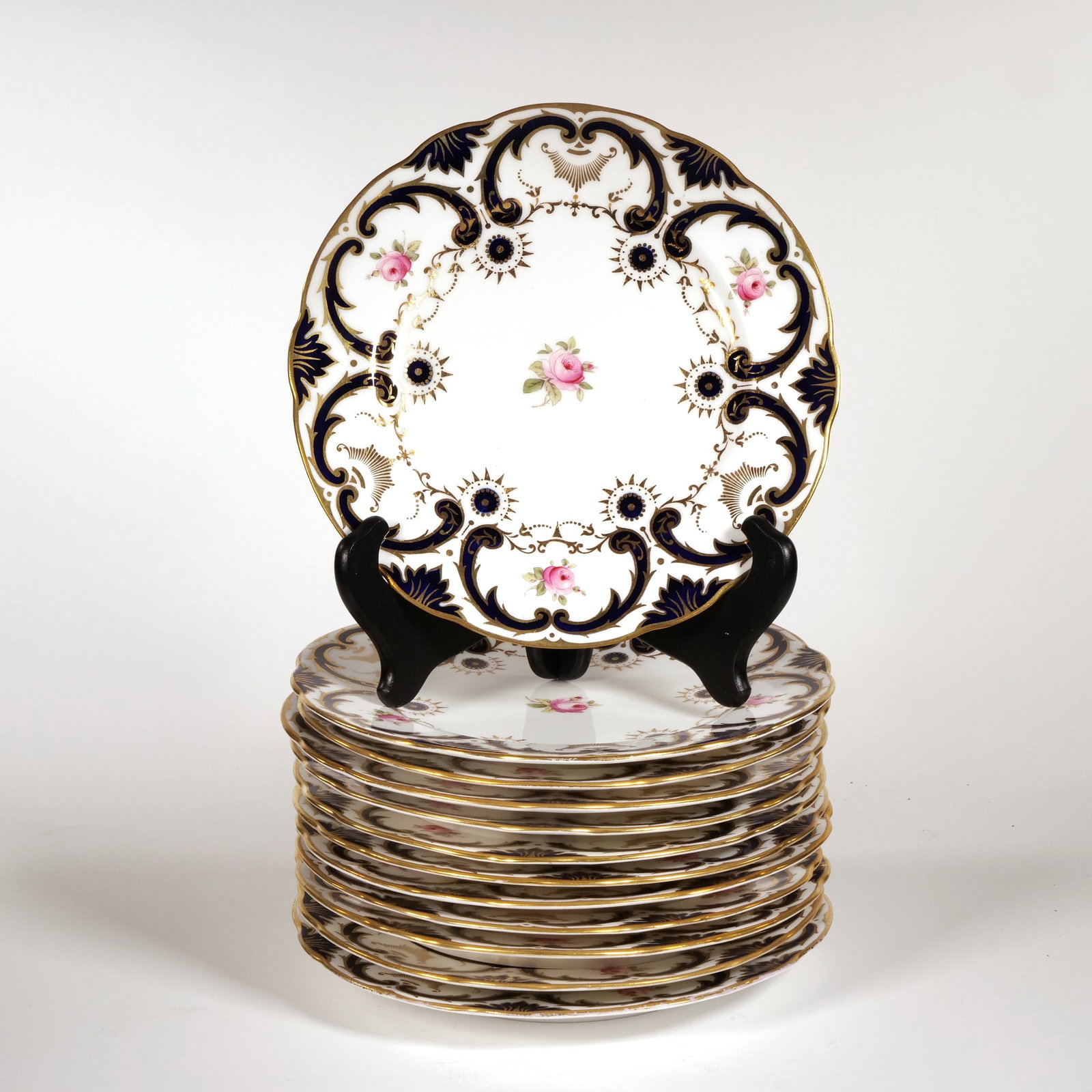 (12pc) COALPORT / TIFFANY & CO. PLATES: Each with hand-painted roses and borders of cobalt and gilt scroll decoration, marked "England Coalport / Leadless Glaze / Tiffany & Co. New York" - dia. 9 in. Provenance: From the estate of a Bre