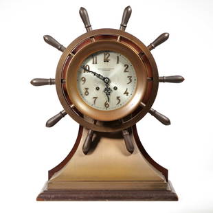 BAILEY BANKS & BIDDLE SHIP'S BELL CLOCK: Yacht wheel ship's clock, art nouveau bronze numerals on a 6-inch silver dial with open work hands; no. 6043 on the bottom - l. 7.5 x w. 14.5 x h. 18 in. Provenance: Items from the estate of an import