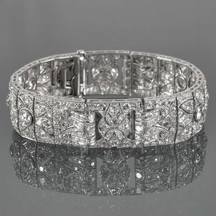 FRENCH ART DECO DIAMOND BRACELET: Style of Cartier; designed as platinum articulating rectangular filigree links set with a line of six old European cut diamonds surrounded with full cut diamonds, two buckle-form sections with raised