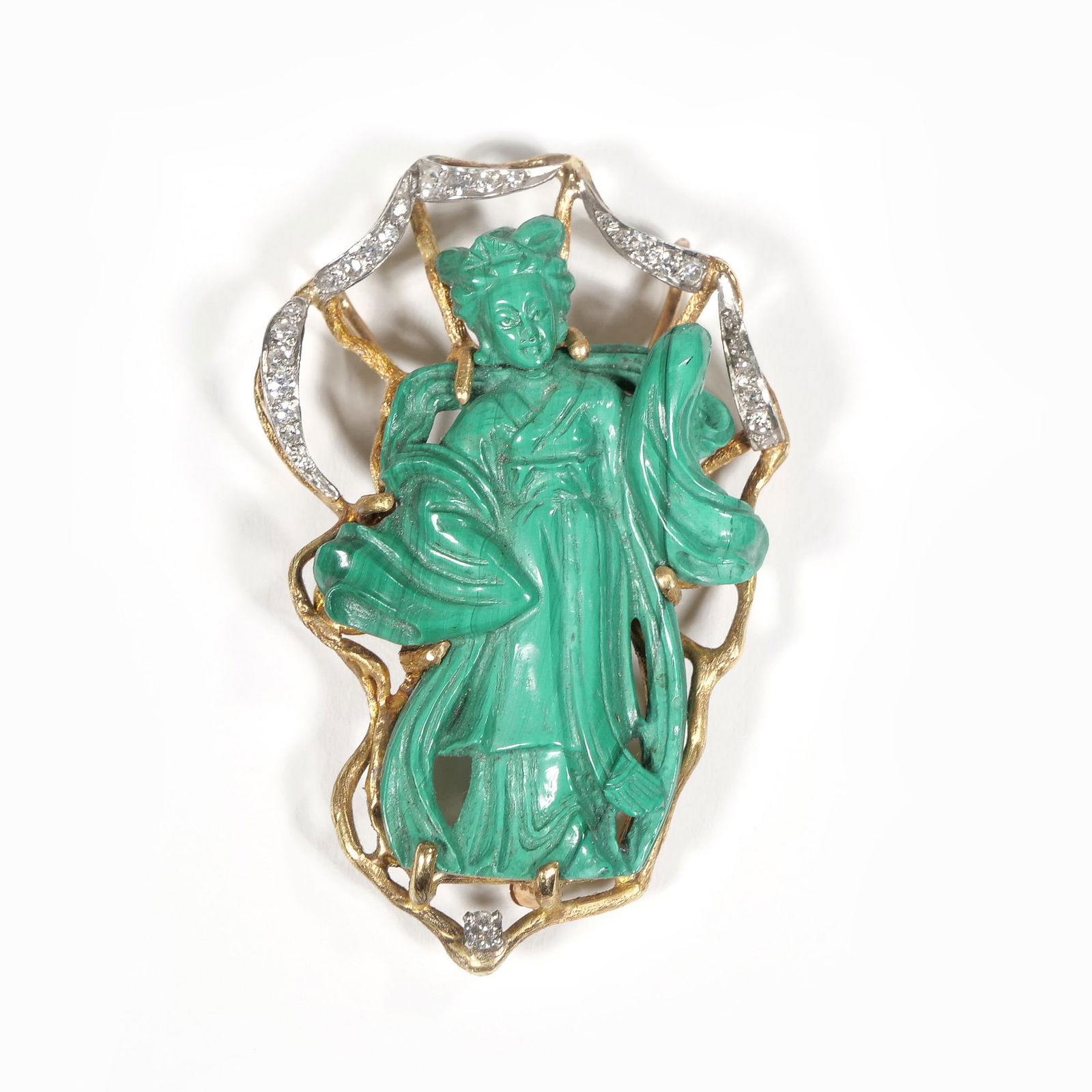 CARVED MALACHITE, DIAMOND & GOLD GUAN YIN BROOCH: Designed as a carved malachite figure of guan yin with flowing robes set within an openwork gold surrounded mounting a ribbon of melee daimonds and one single full cut diamond below the figure 2.25 in