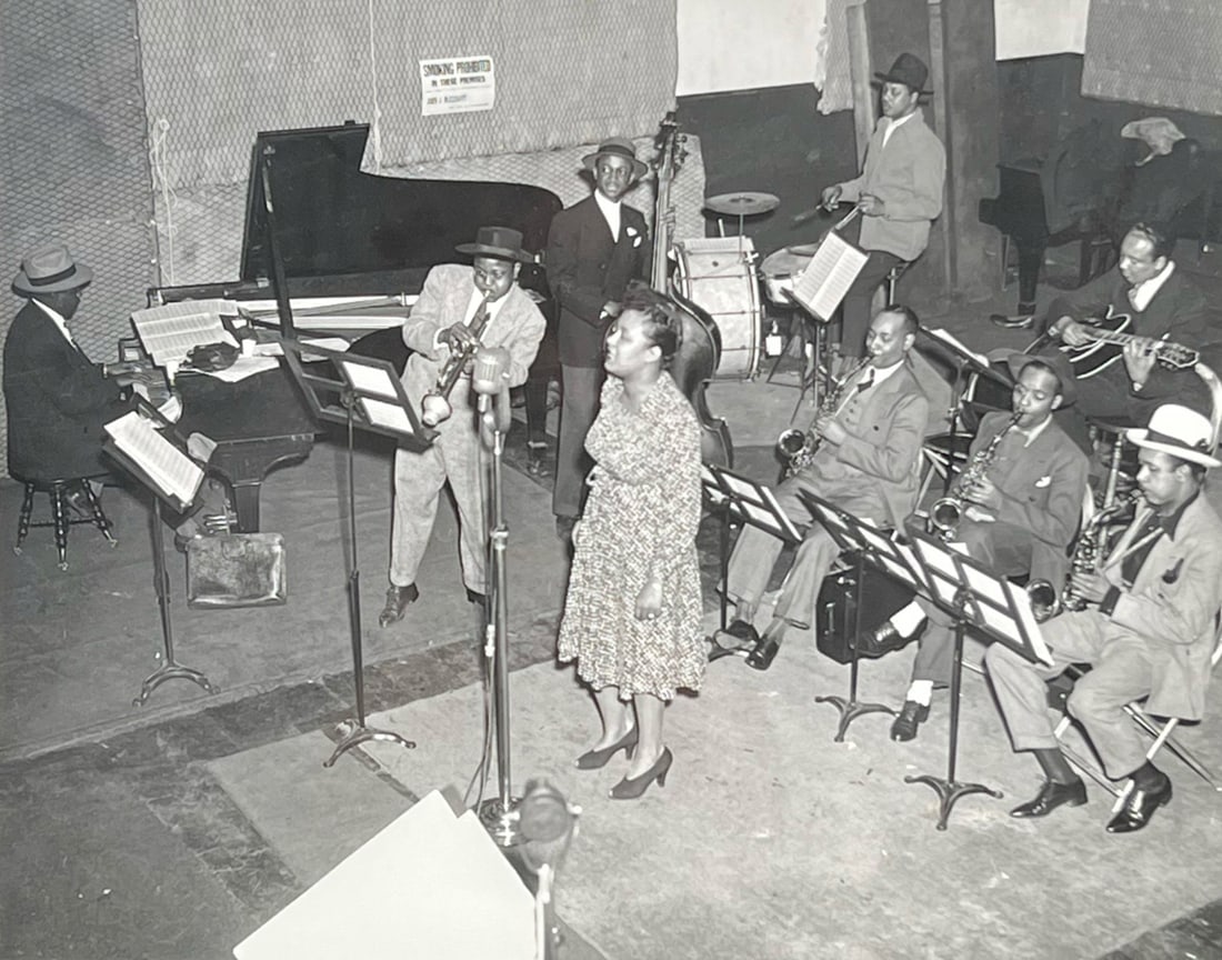 BILLIE HOLIDAY PHOTOGRAPH, RECORDING STUDIO 1940: Billie Holiday in the studio at a recording session in New York L-R Sonny White - piano, Roy Eldridge - trumpet, John Williams - bass, Billie Holiday, Hal West - drums, Jimmy Powell, Carl Frye - alto