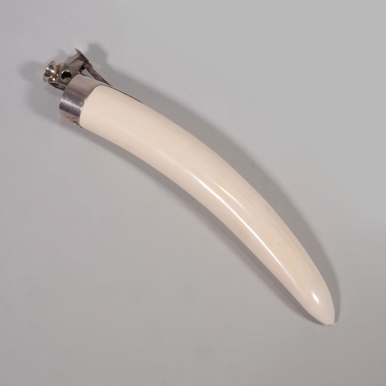 935 STERLING WALRUS TUSK GERMAN CIGAR CUTTER: Marked 935s to top Makers mark of Pfeilring Solingen to the metal cutter part of the item h. 2 x w. 3 x l. 12 x d. 2 x dia. 2 in. Provenance: Items from the private collection of music industry titan