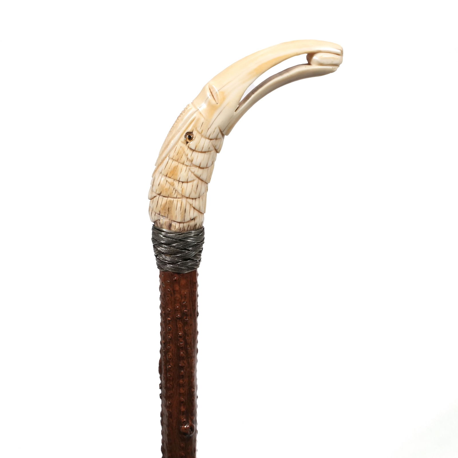 BROT PALAIS ROYALE CARVED BONE TOUCAN-FORM WALKING STICK / CANE: Carved bone Head of a toucan grasping a small oval seed, glass eyes with a silver thread collar & brass ferrule&nbsp; l. 33 x d. 4 x dia. 4 in. Provenance: Items from the private collection of