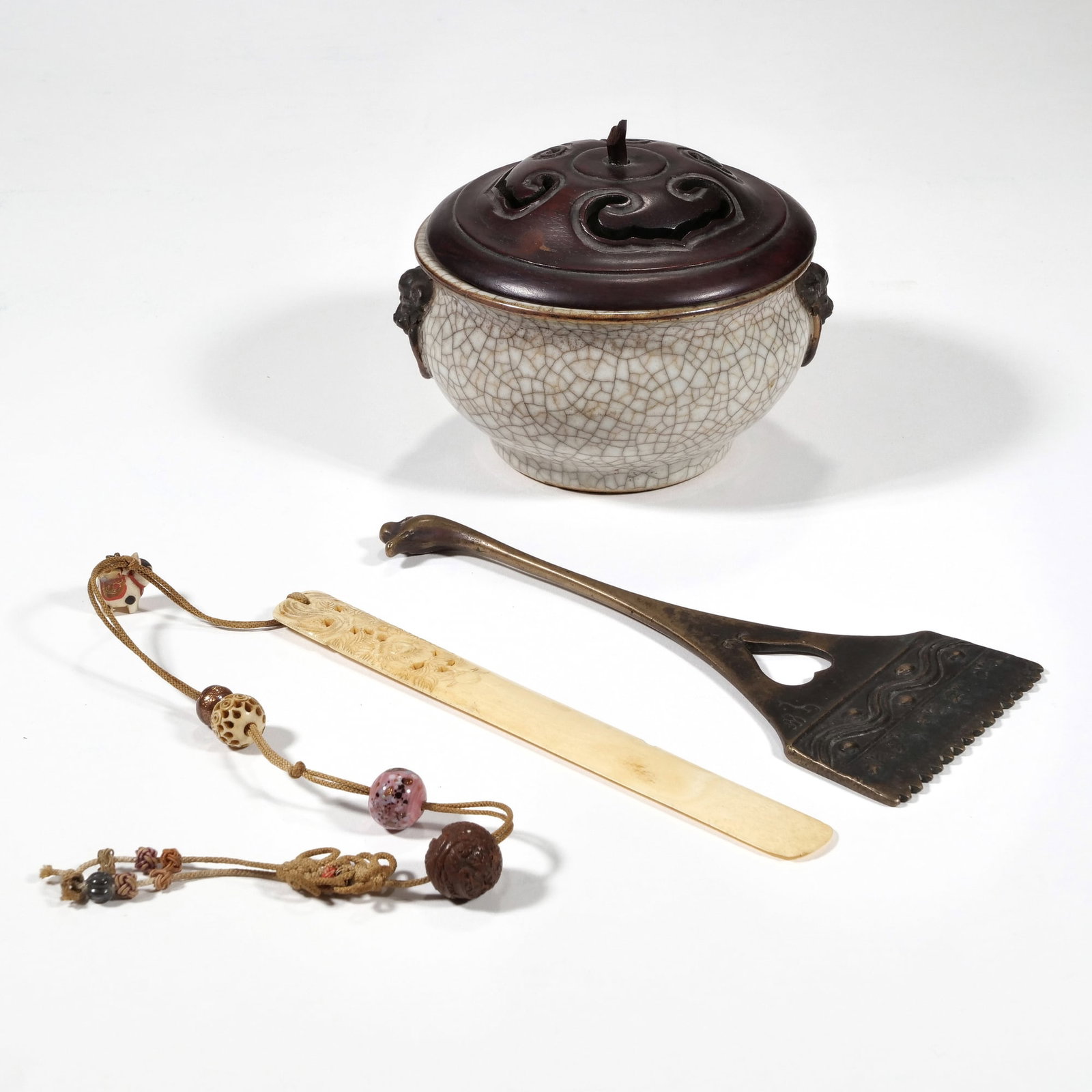 (3pc) MIXED CHINESE / JAPANESE TABLE OBJECTS: Including a crackle glazed vase with foo dog mounts and a carved wood lid, a bronze rake with a goose-head form end, and a carved bone page turner h. 4.5 x w. 4.75 in. (Bowl) Provenance: Items descend