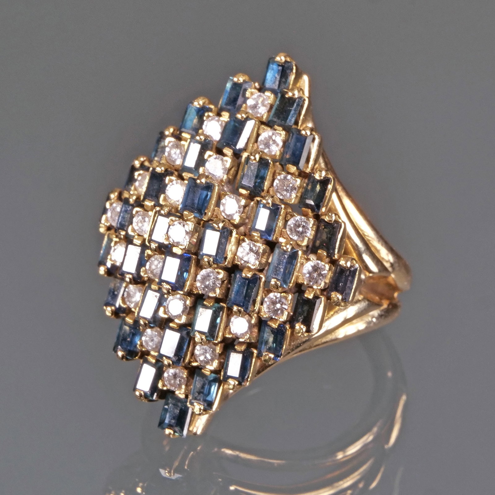 SAPPHIRE, DIAMOND, & 14K GOLD RING: Designed in a marquis shape, set with alternating baguette sapphires (or other blue stones) and round diamonds (tested), having no apparent fineness mark but tested to 14k yellow gold; size 4.25; 14.8