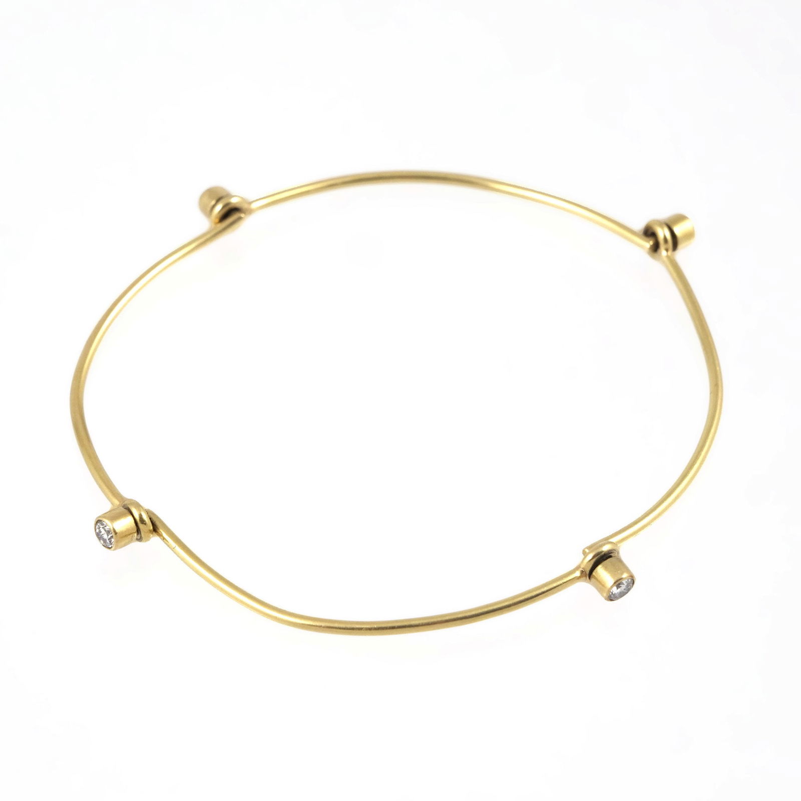 18K GOLD & DIAMOND WIREWORK BRACELET: 18k yellow gold bracelet having four articulating hinges each mounting a single diamond (bracelet folds into quarters), internal diam. approx. 2.5 in.; no apparent fineness mark, tested to 18k gold; g