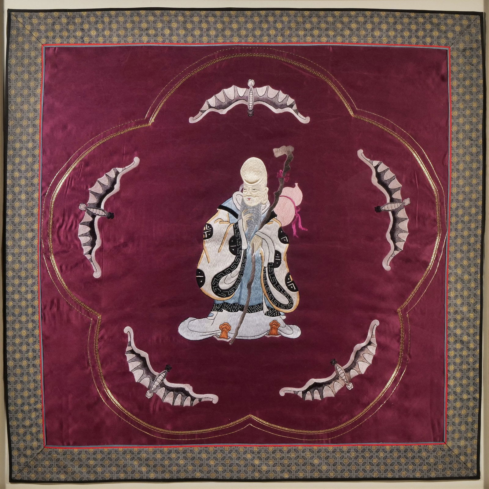 A CONTEMPORARY CHINESE EMBROIDERED PANEL OF A SAGE: Chinese silk embroidered panel showing a wise sage figure surrounded by five bats h. 33 x 33 in. (panel) h. 36 x w. 36 in. (frame)