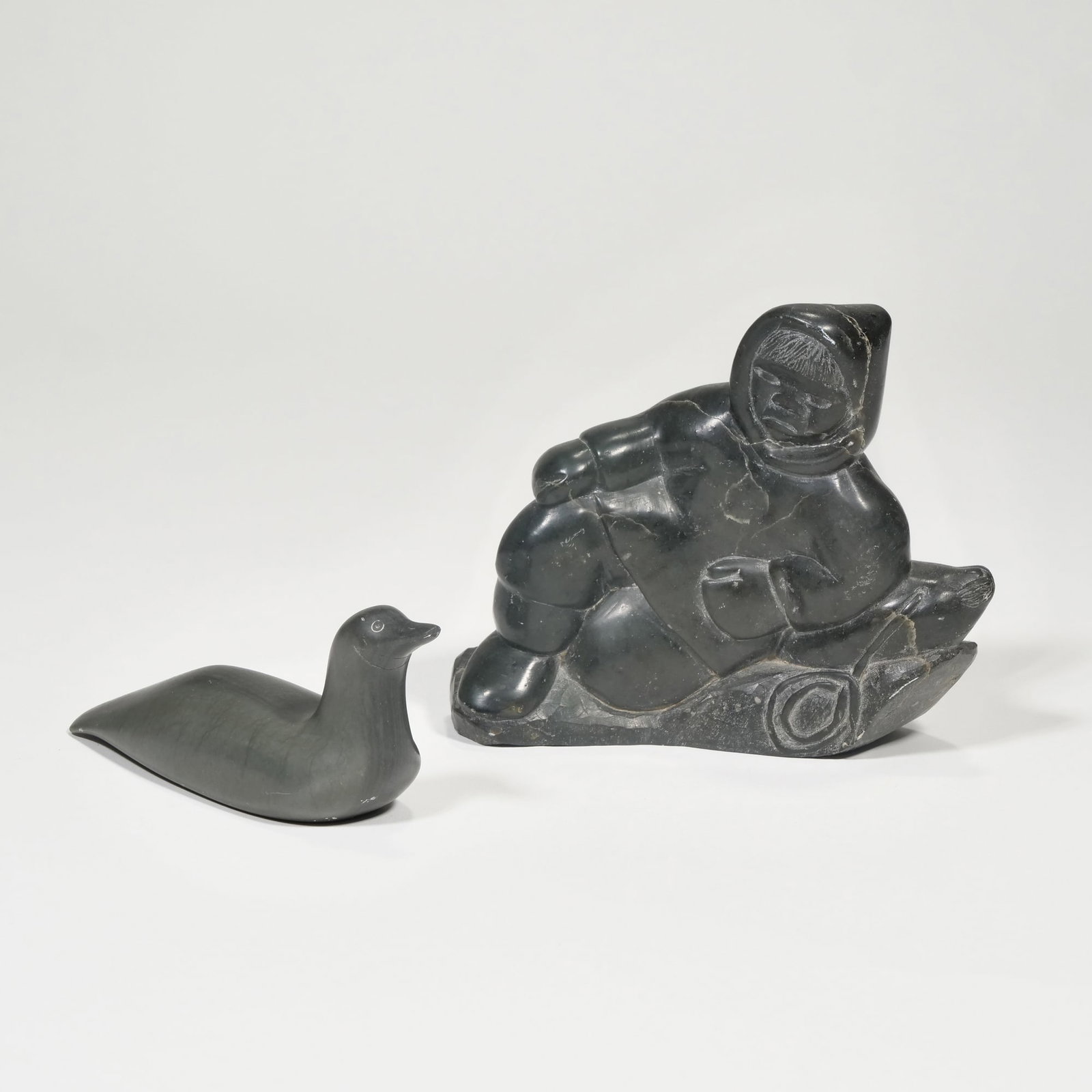 (2pc) INUIT CARVINGS: Including a reclining figure (larger) and a water fowl, both with markings to base h. 5 x w. 6 in. (tallest)