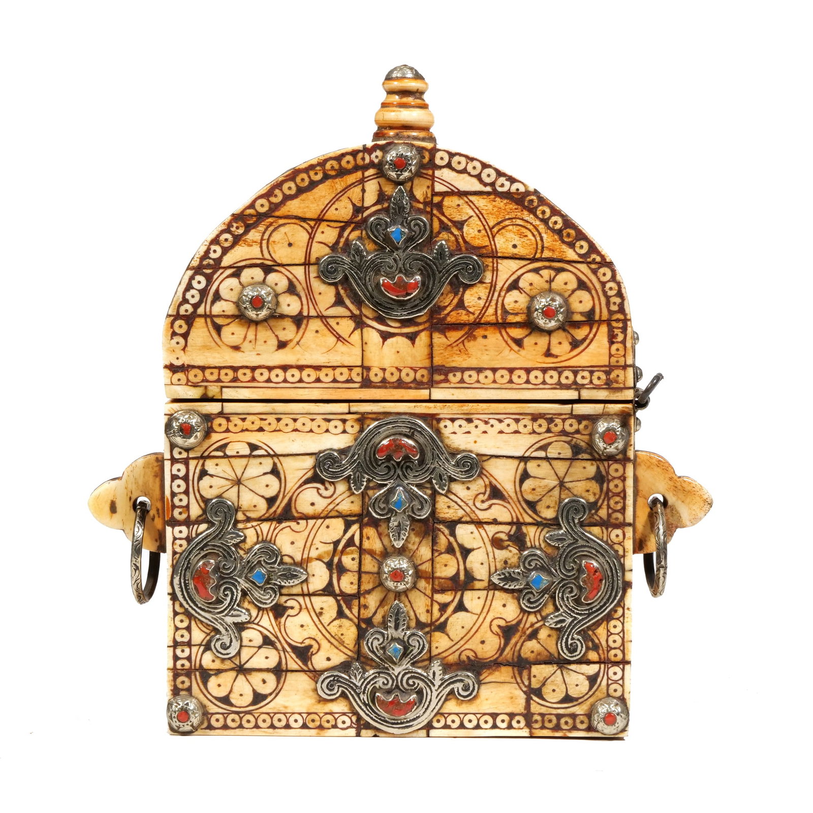 MOROCCAN BERBER BONE-INLAID AMULET CASE WITH SILVER FILIGREE AND SEMI-PRECIOUS STONES: The arched case features bone veneer panels decorated with incised geometric floral patterns and circular motifs. Silver-tone metal filigree overlays are applied across the front, set with red and blu