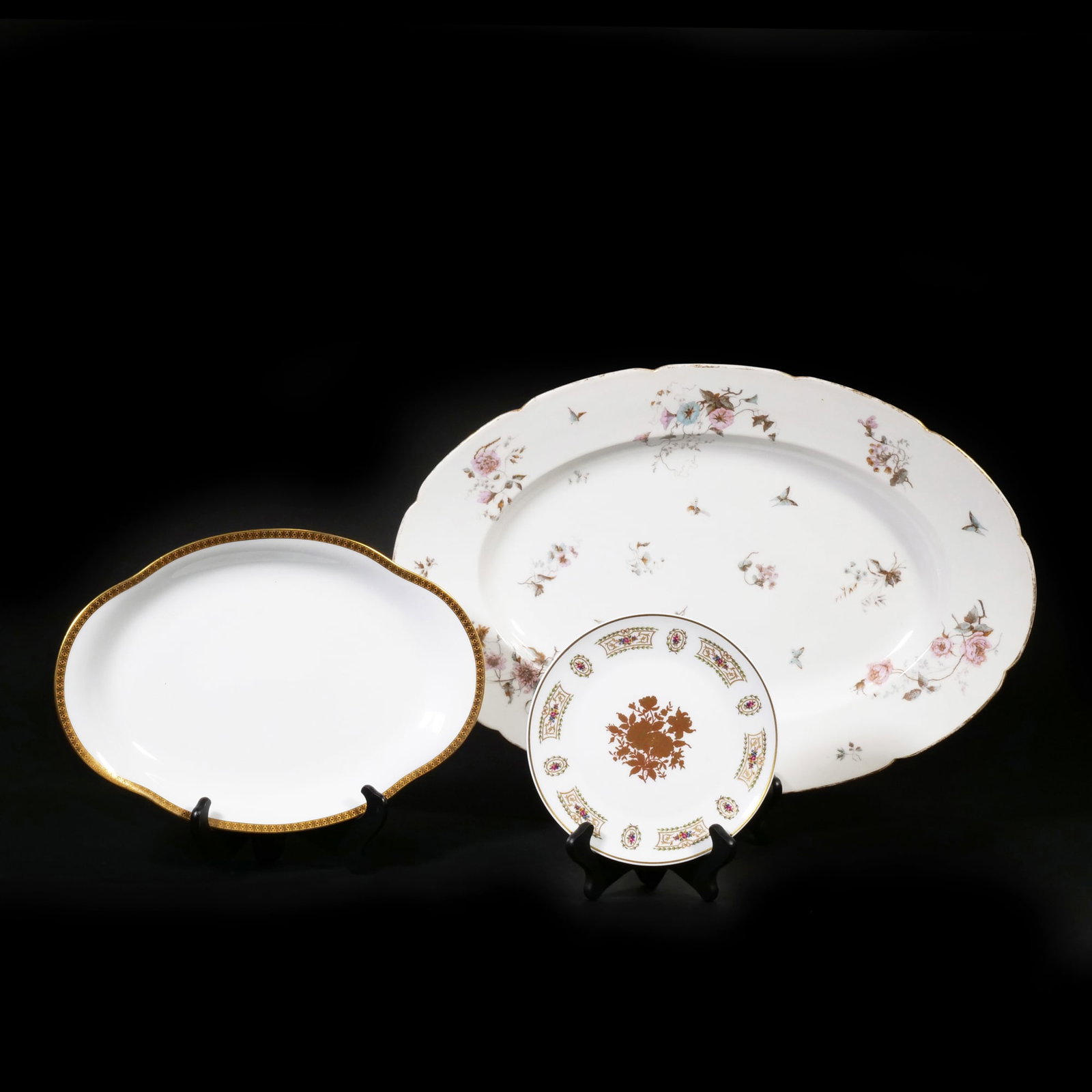(3pc) LIMOGES & OTHER FRENCH PORCELAIN PLATTERS: Porcelain serving dishes, including a large oval platter decorated with polychrome floral sprays, morning glories, and various insects. A medium oval Limoges dish features a wide gilt border with a re