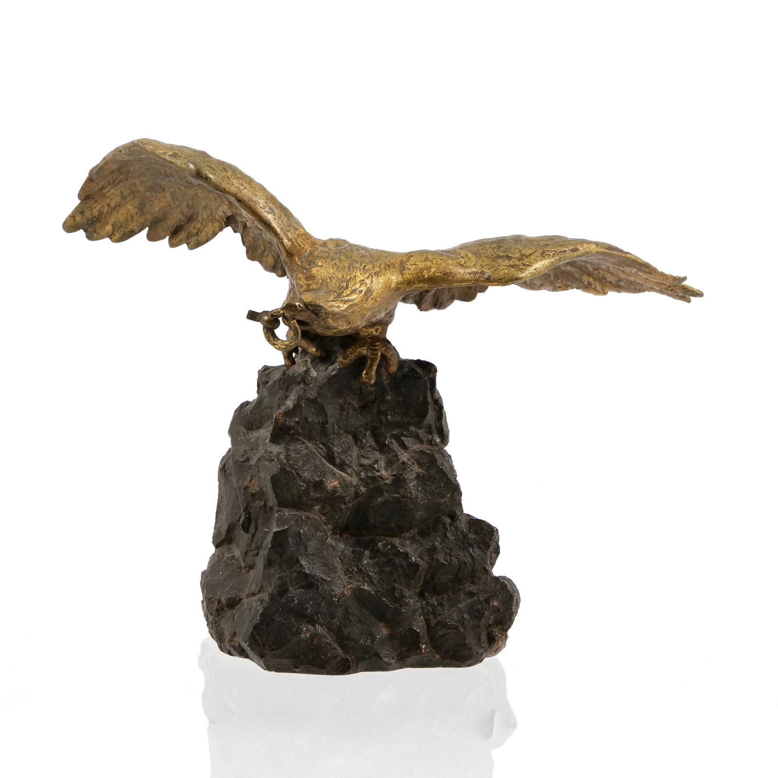 19TH C. GILT BRONZE EAGLE ON ROCK POCKET WATCH STAND: This gilt bronze sculpture features an eagle with outspread wings perched on a dark, patinated rock-form base. The eagle holds a small metal ring in its beak, designed to suspend a pocket watch. Detai