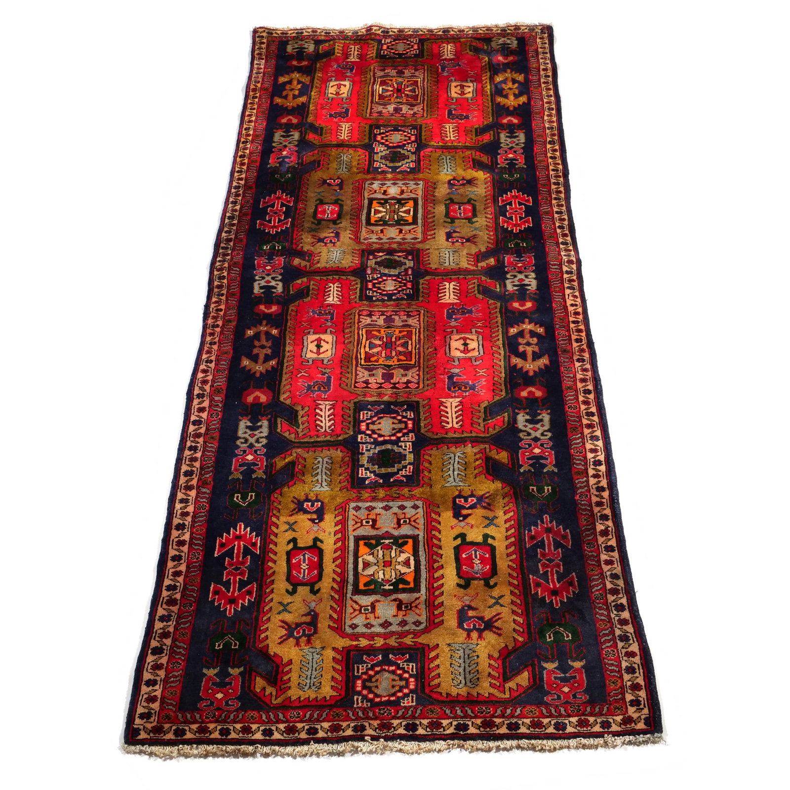 CAUCASIAN STYLE HAND-KNOTTED WOOL RUNNER WITH GEOMETRIC MOTIFS: Hand-knotted wool runner featuring a field of alternating red and ochre geometric medallions. The central medallions are flanked by stylized zoomorphic figures and latch-hook designs against an