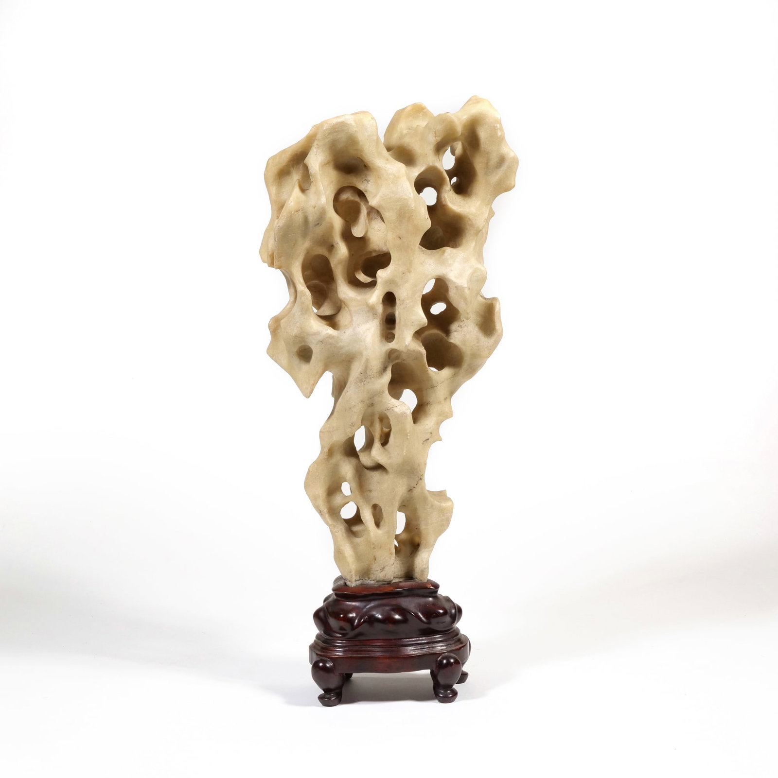 CHINESE SCHOOL (20TH CENTURY) TAIHU STONE SCULPTURE: Scholar's Rock Taihu-style limestone h. 13 x w. 7.5 in. (stone), h. 16.25 in. overall The vertical stone formation features numerous naturalistic perforations and a textured, pale beige surface. It is
