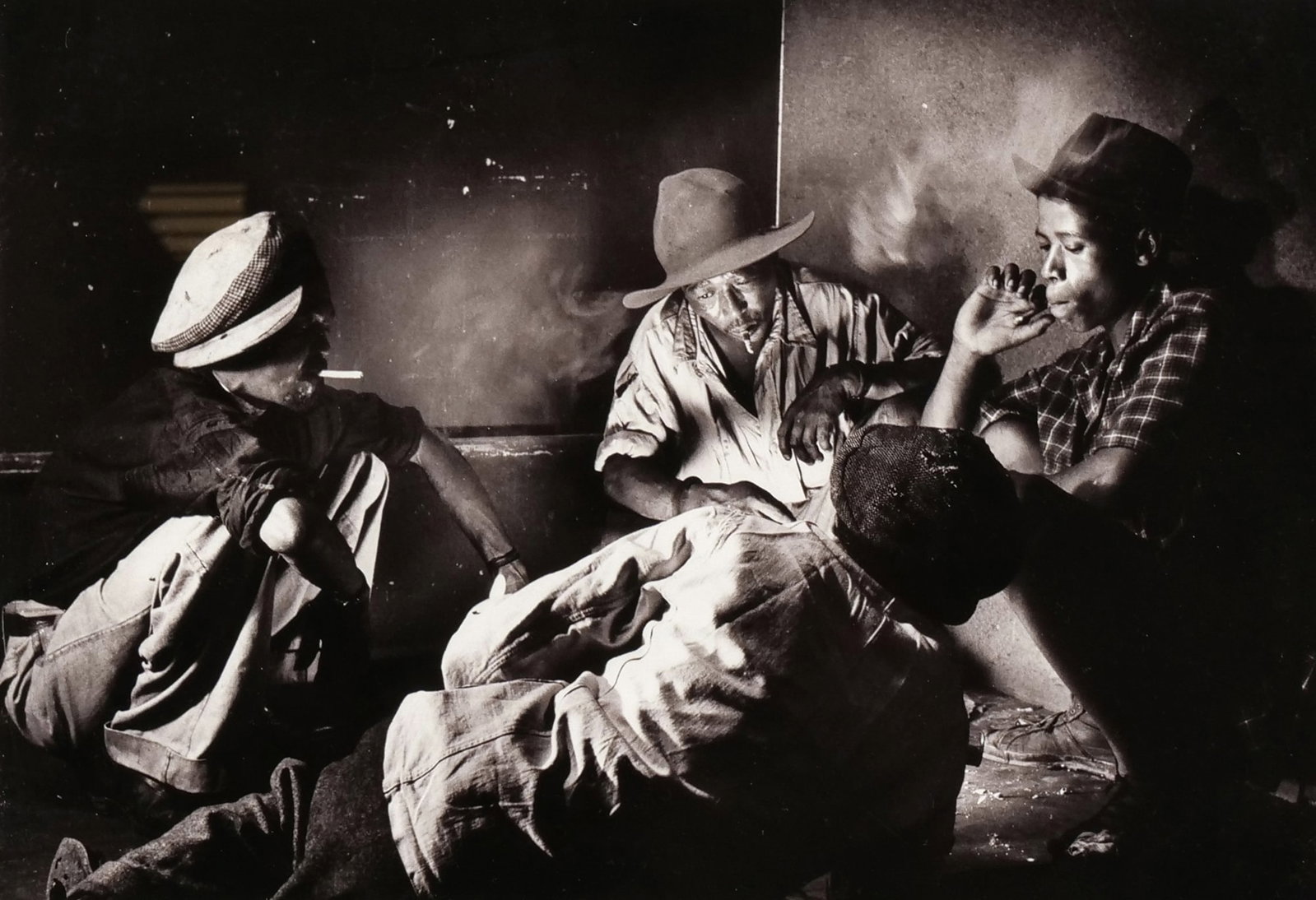 JURGEN SCHADEBERG (GERMAN/SOUTH AFRICAN, 1931-2020) PHOTOGRAPH: Smokers, Sophiatown, 1954Signed and embossed lower rightTitled and dated lower left9.5 x 13.5 in. (subject) - h. 17 x w. 21 in. (frame) Inventory No. 64-64 Provenance: With Axis Gallery, NYC, label on