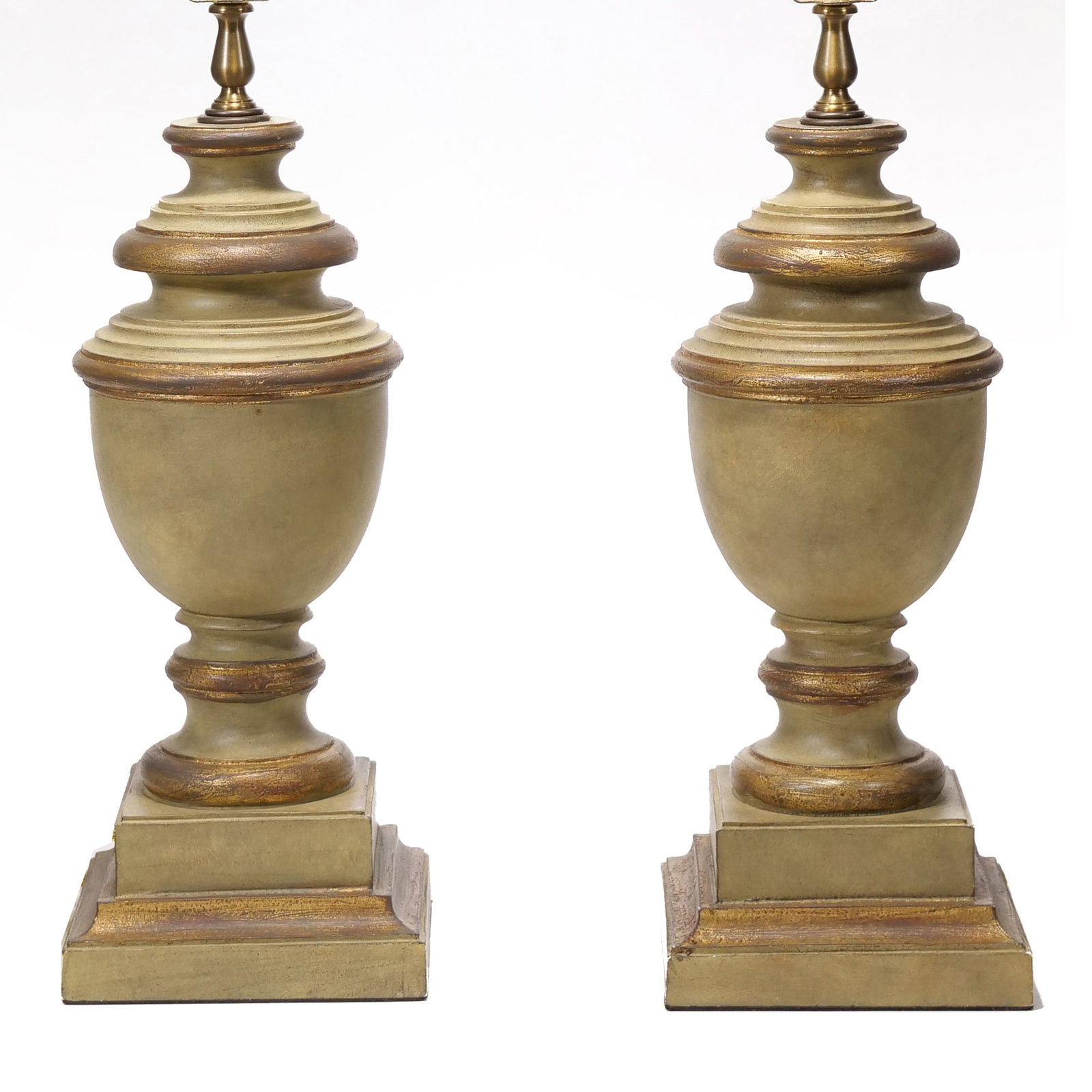 PAIR OF CHELSEA HOUSE PAINTED URN-FORM TABLE LAMPS: Pair of Chelsea House table lamps featuring urn-shaped bodies on tiered square pedestal bases. The lamps are finished in an antiqued sage green and gold paint. Brass sockets are stamped with "Chelsea 