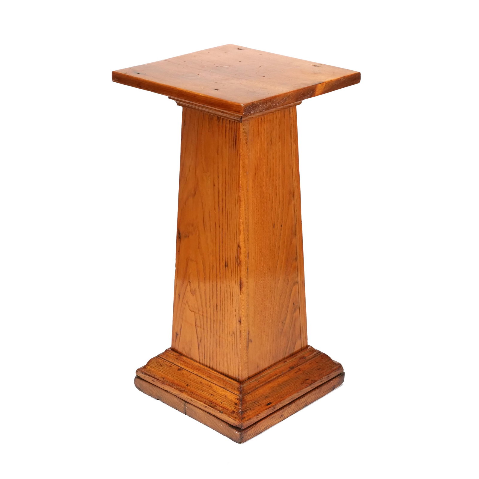 PINE COUNTRY STYLE PEDESTAL DISPLAY STAND: Constructed from pine with a honey-colored finish, this pedestal features a tapered rectangular column. The design includes a flat square top and a multi-tiered molded base. Visible wood grain and