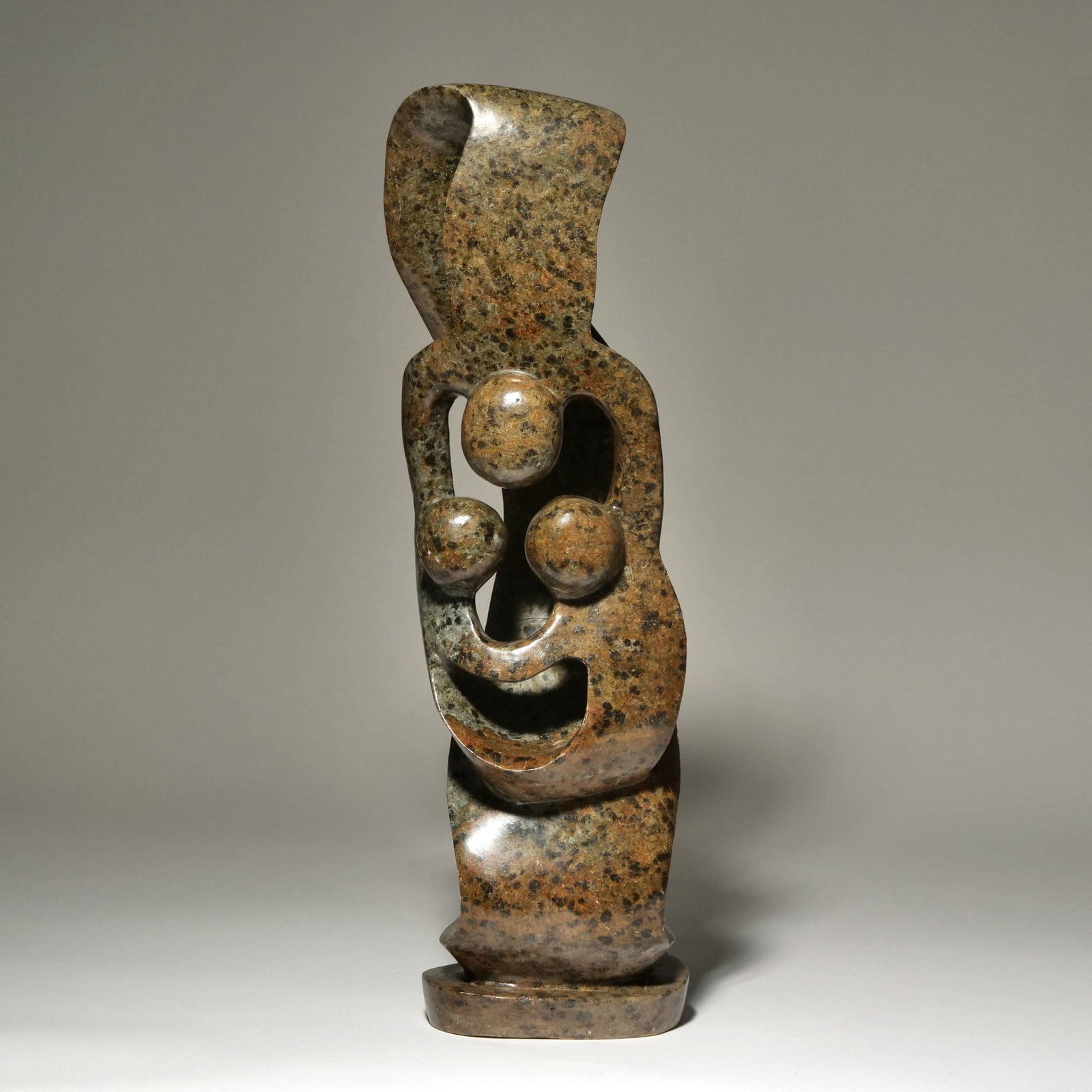 AFRICAN STONE CARVING: Carved shona stone sculpture depicting three intertwined figures, marked 'Made in Zimbabwe' on base - h. 25 x w. 6 in. Inventory No. 93-62 Provenance: Items from the estate of a Greenwich, CT lady.