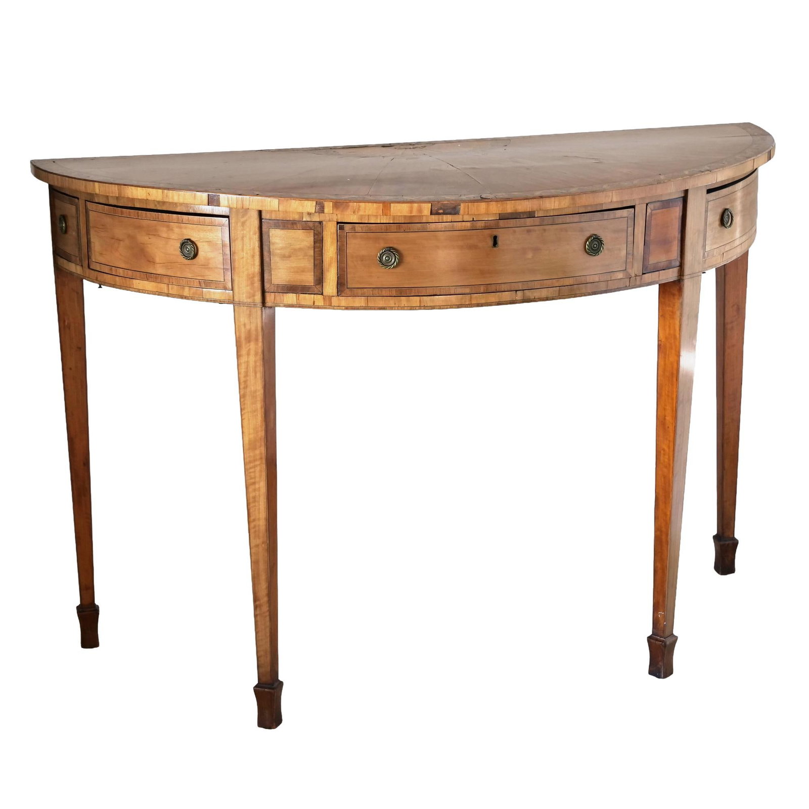 GEORGE III INLAID SATINWOOD DEMI-LUNE CONSOLE TABLE: Demi-lune (half-moon) console table in satinwood veneer with inlaid stringing and fan (sunburst) marquetry at the center of the top. Three concave front frieze drawers (central drawer with key escutch