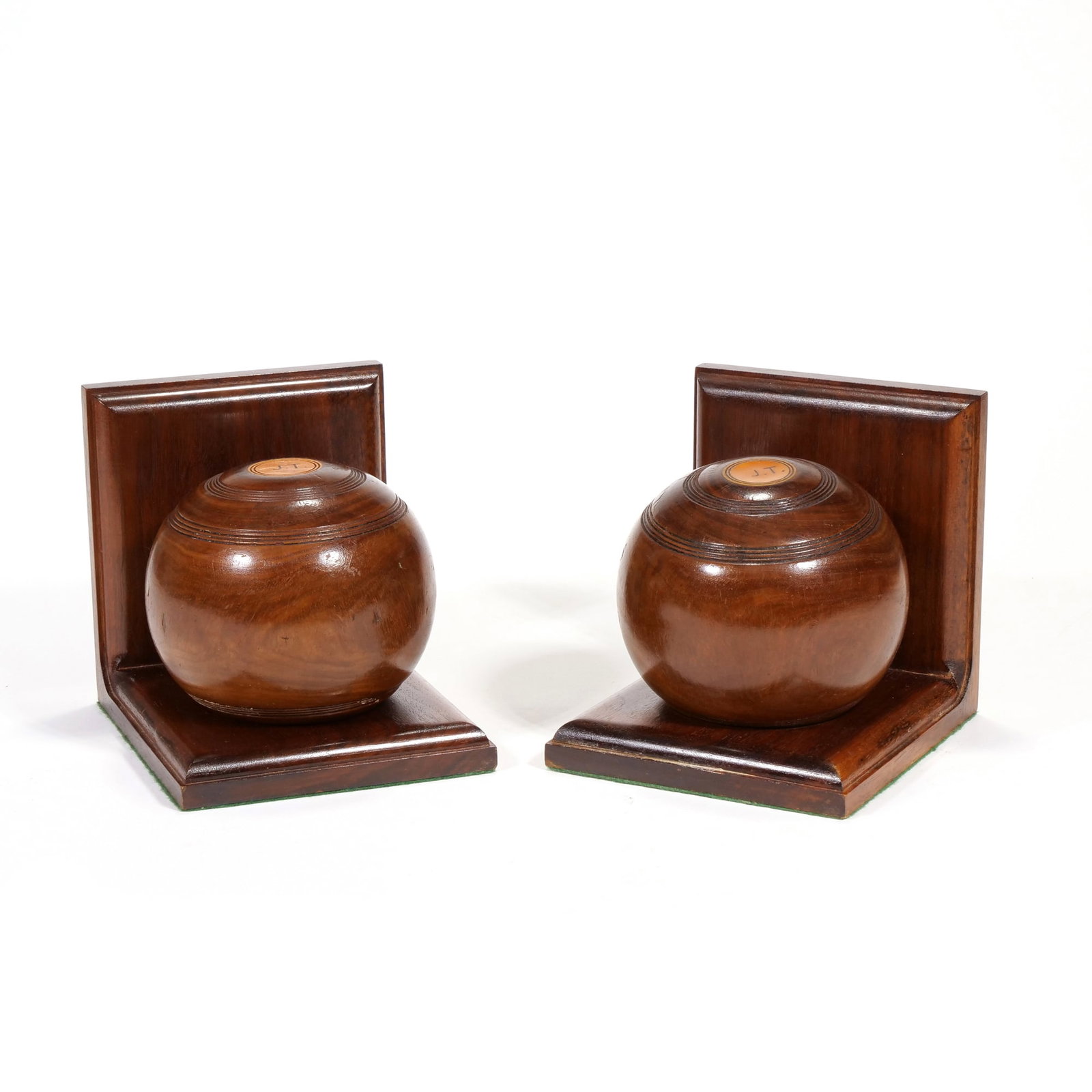 (2pc) PAIR OF VINTAGE WOODEN LAWN BOWLING BALL BOOKENDS: Each bookend features a dark stained wooden L-shaped base supporting a detachable spherical lawn bowl. The spheres are detailed with concentric circular grooves and a light-colored inlay at the pole e