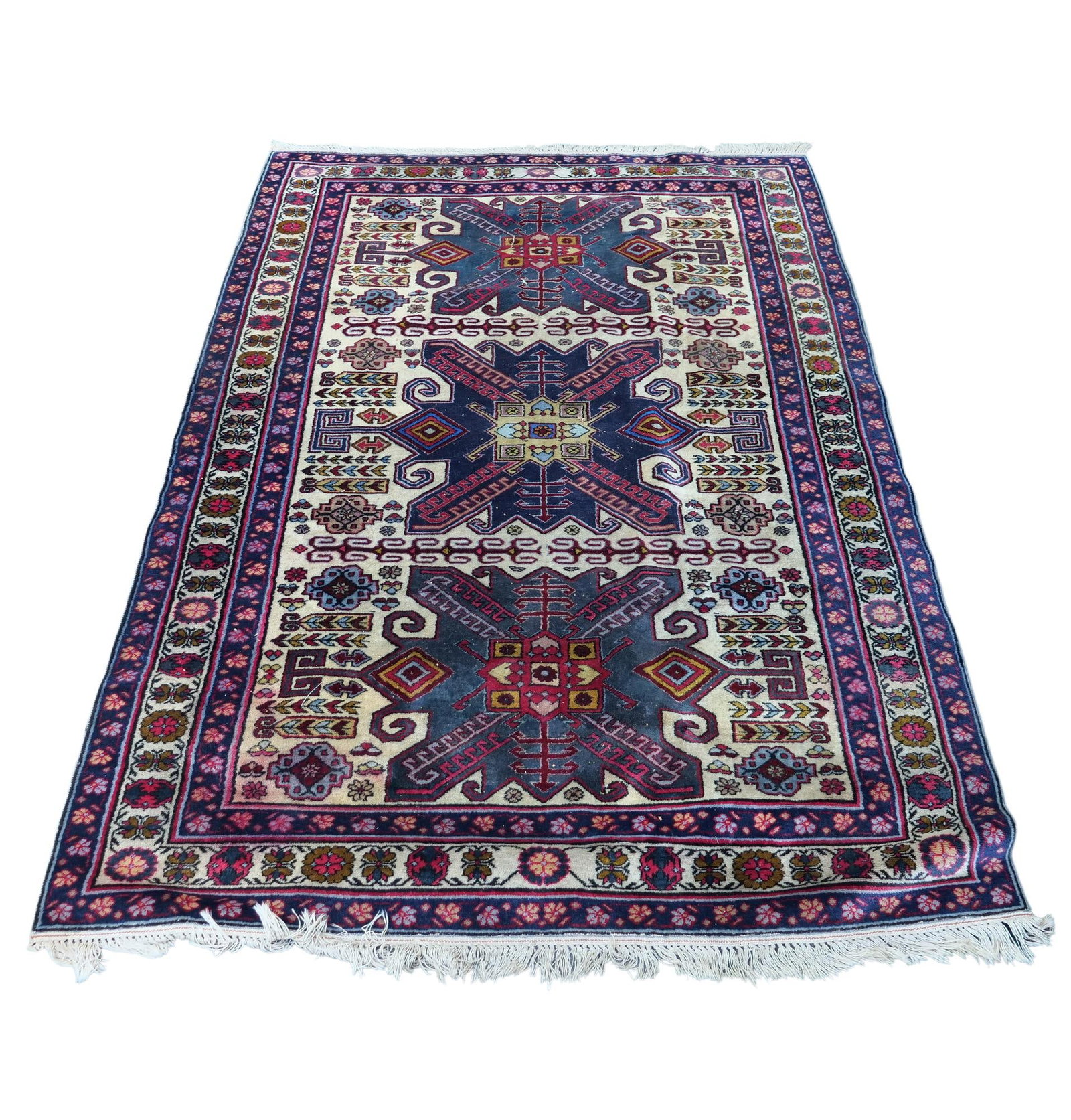 CAUCASIAN STYLE KAZAK HAND-KNOTTED WOOL RUG: This hand-knotted wool rug features three large geometric medallions set against an indigo and ivory field. The central motifs are surrounded by various tribal elements, including stylized geometric