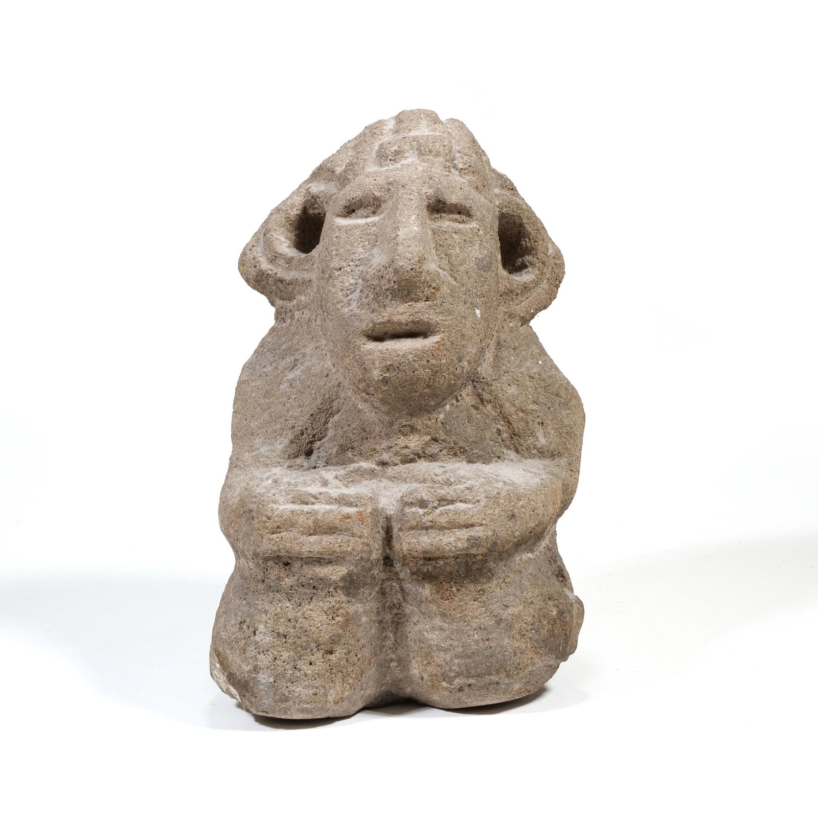 MAYAN STYLE (20TH CENTURY) CARVED STONE SCULPTURE: Kneeling Figure Carved stone h. 10.75 x w. 6.75 x d. 5 in. This carved volcanic stone sculpture depicts a kneeling anthropomorphic figure with hands resting on the knees. The figure features large per