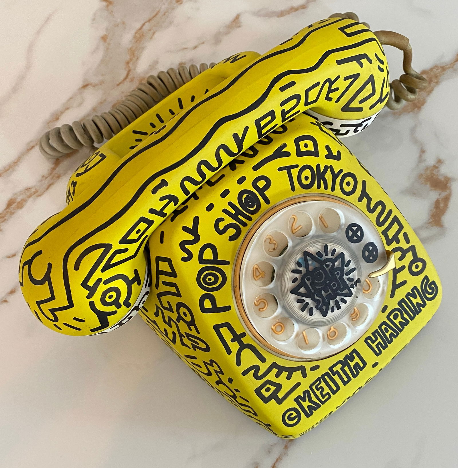 Keith HARING (1958-1990), Style Of. Téléphone Pop Shop Tokyo, 1987.: Pop Shop Tokyo Telephone, 1987. Paint and black marker drawings on a fully painted metal and plastic rotary telephone. dated under the base. Annotated "Pop Shop" and "Keith Haring." A rare and strikin