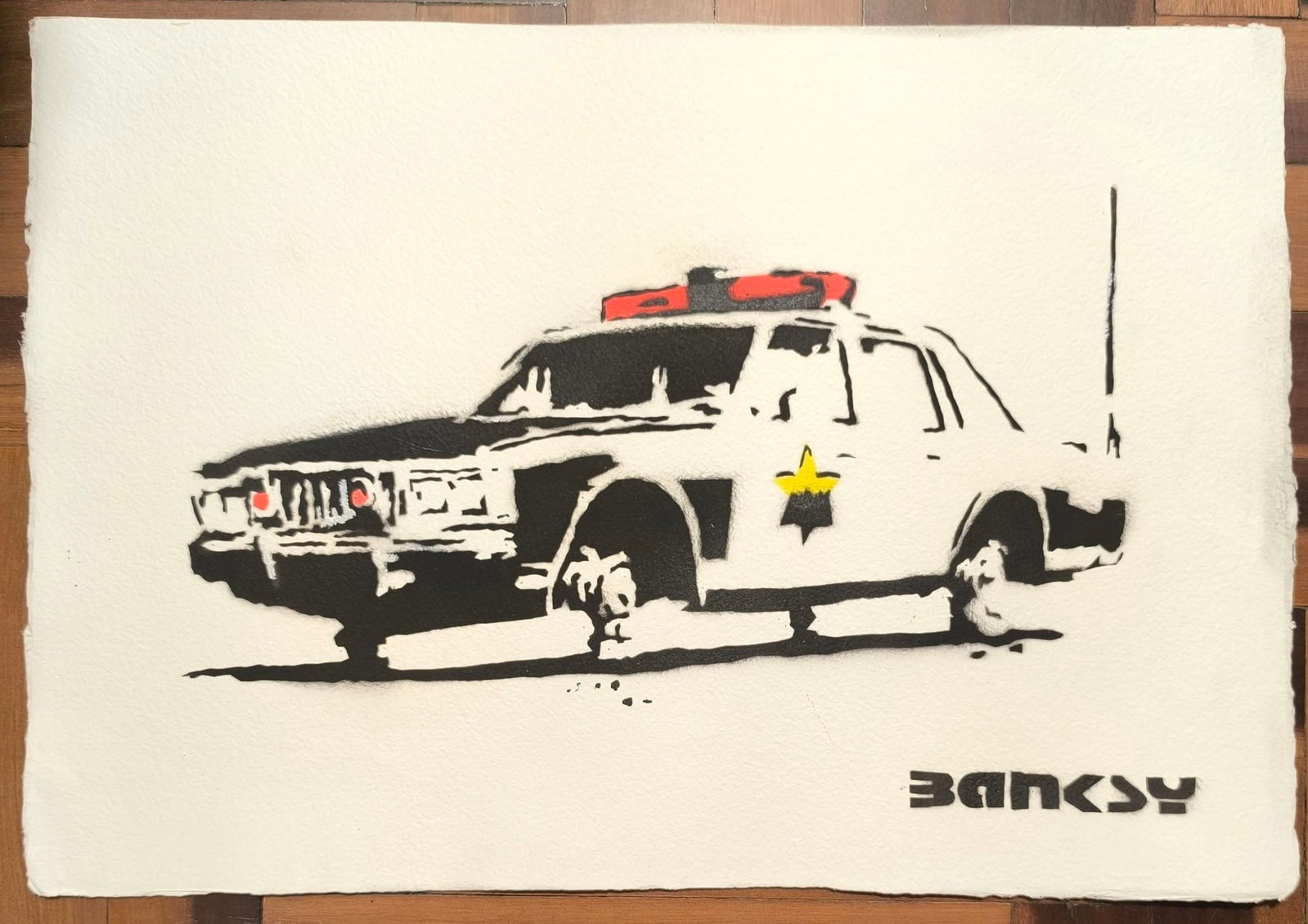 BANKSY (B. 1974), "POLICE CAR", STENCIL SPRAY ON PAPER (Style Of): This lot consists of a Stencil Spray On Paper in the style of the painter Banksy. Banksy is a British street artist. He is one of the most media-savvy and controversial figures in the art scene of the