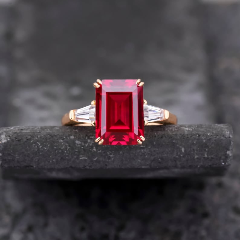 Certified 9.00 Carat Emerald Cut Lab Grown Ruby Engagement Ring in 14K Rose Gold Three Stone Ring |: Certified 9.00 Carat Oval Cut Lab Grown Ruby Engagement Ring in 14K Rose Gold Three Stone Ring | Luxury Promise Ring |Side Stone Lab Grown Diamonds VVS1 D Color Fancy Cut 0.60 ct - Ring Size US 7