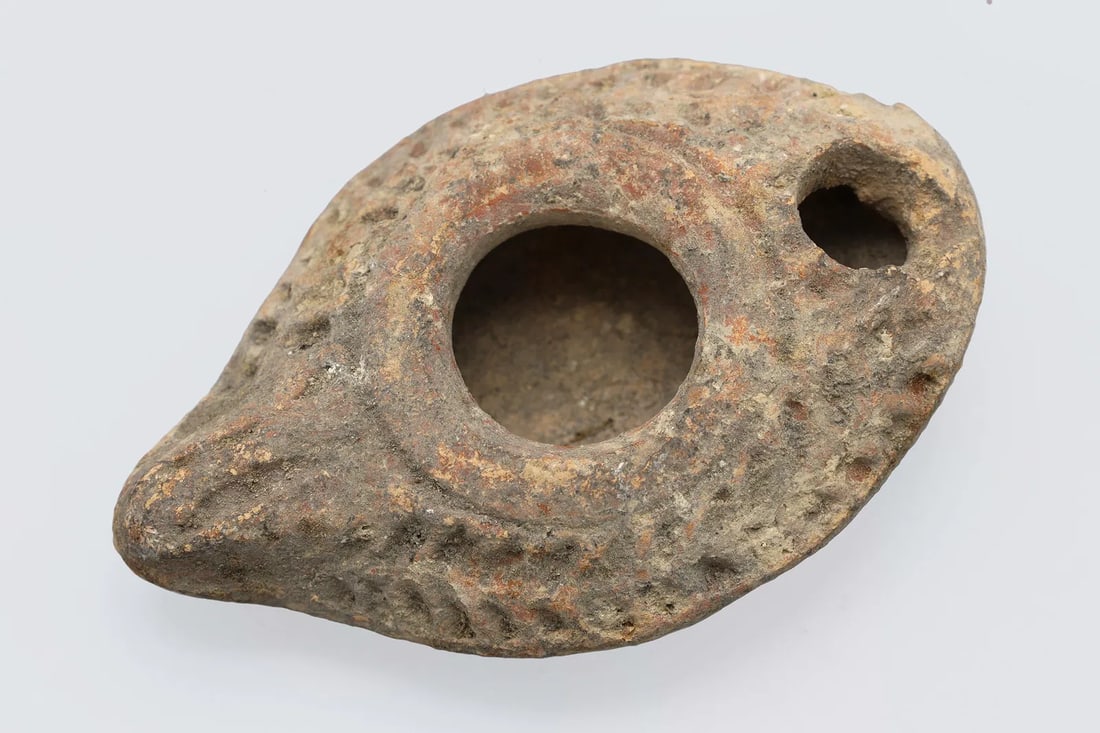 Holy Land Terracotta Oil Lamp, Palestine Under Roman Empire, Circa 3rd Century AD, Antiquities Art: Holy Land, Levant. Ancient Pale Tones Terracotta Oil Lamp, Palestine Under Roman Empire, Circa 3rd Century AD. Dimensions Length 3 inches. All Measurements Are Approximate. No Visible Repairs Or Damag