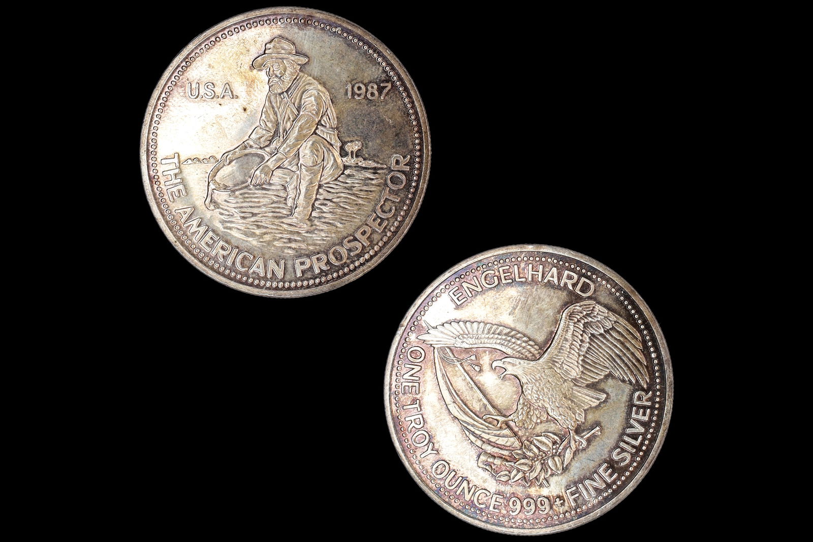 1 Troy Ounce Of 999 Silver, 1987 Engelhard Mint The American Prospector, USA Rounds Bullions: 1 Troy Ounce Of 999 Silver, 1987 Engelhard Mint The American Prospector, USA Rounds Bullions, Diameter 39.8 mm, Weight 31.2 grams. Obverse: A man kneeling, facing left, while panning for precious meta