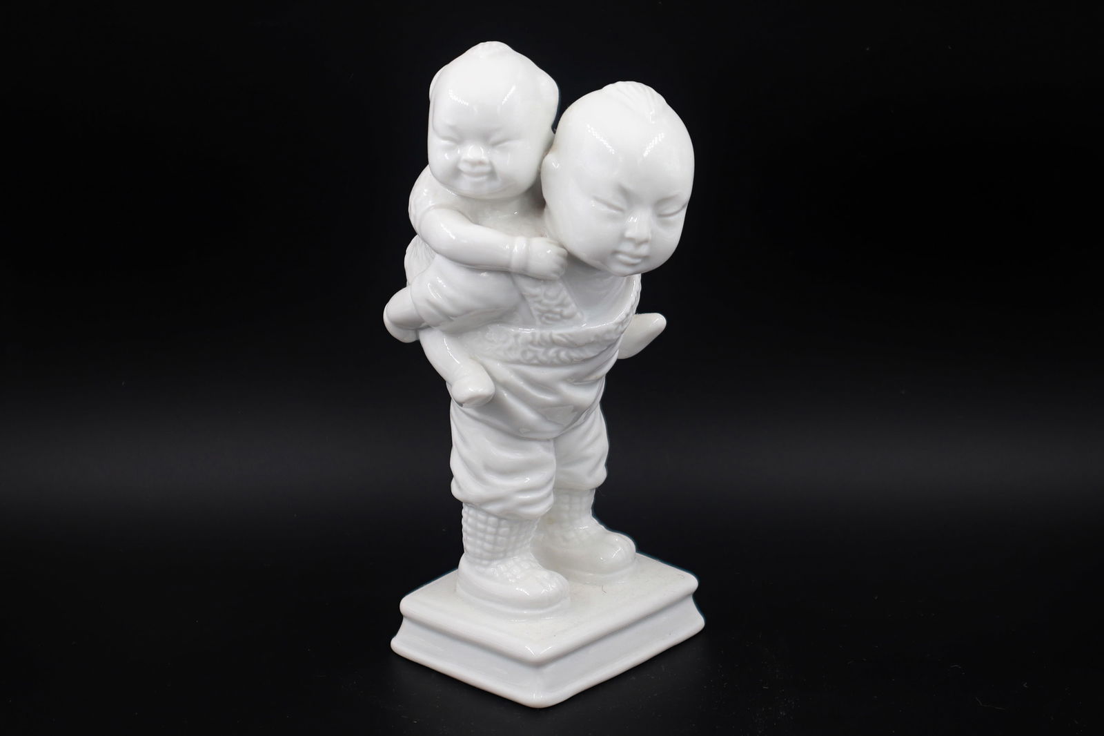 Scarce Piece, A 1978 Fitz & Floyds White Porcelain Figurine Of A Boy Carrying Toddler On His Back: Dimensions 5.75 inches Height. All measurements are approximate. Provenance: Private Collector New York USA, Purchase At London UK Auction. // Scarce Piece, A 1978 Fitz & Floyds White Porcelain Figuri