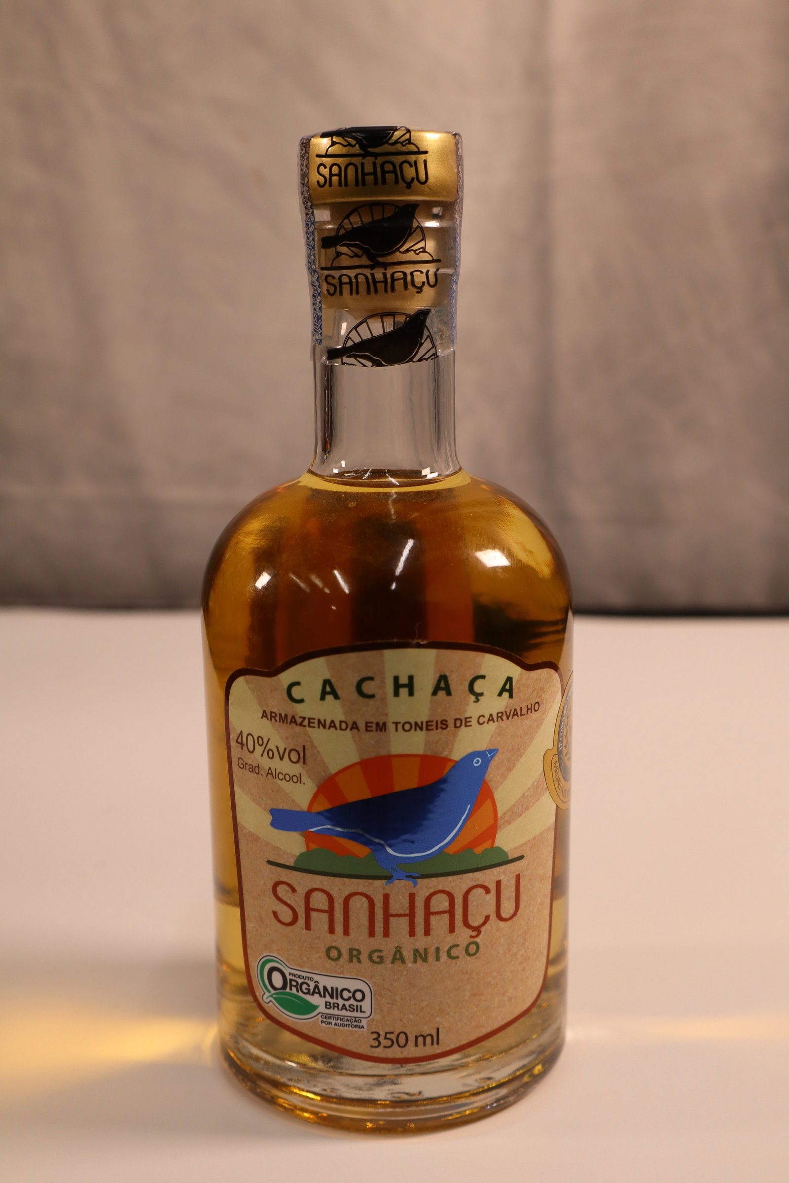 Cachaça "Sanhaçu" Orgânico - Brazil: A premium Brazilian cachaça, "Sanhaco" Orgânico, presented in a 350ml bottle. This handcrafted cachaça is produced from organically grown sugarcane, ensuring a pure and authentic flavor profile. Kn