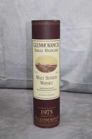 Glenmorangie Single Highland Malt Scotch Whisky 1975: Original cylindrical presentation box in burgundy with gold details, including Glenmorangie branding and distillation date. This 1975 vintage Glenmorangie is a rare collector’s item from one of Scot