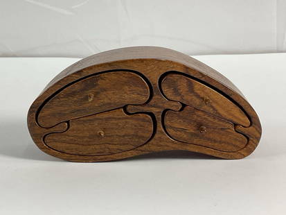 "Handcrafted Wooden Storage Box" by Richard Rothbard: This handcrafted wooden puzzle box features a kidney-shaped design with four interlocking drawers. The drawers, each with a small wooden knob, slide out smoothly to reveal hidden compartments perfect