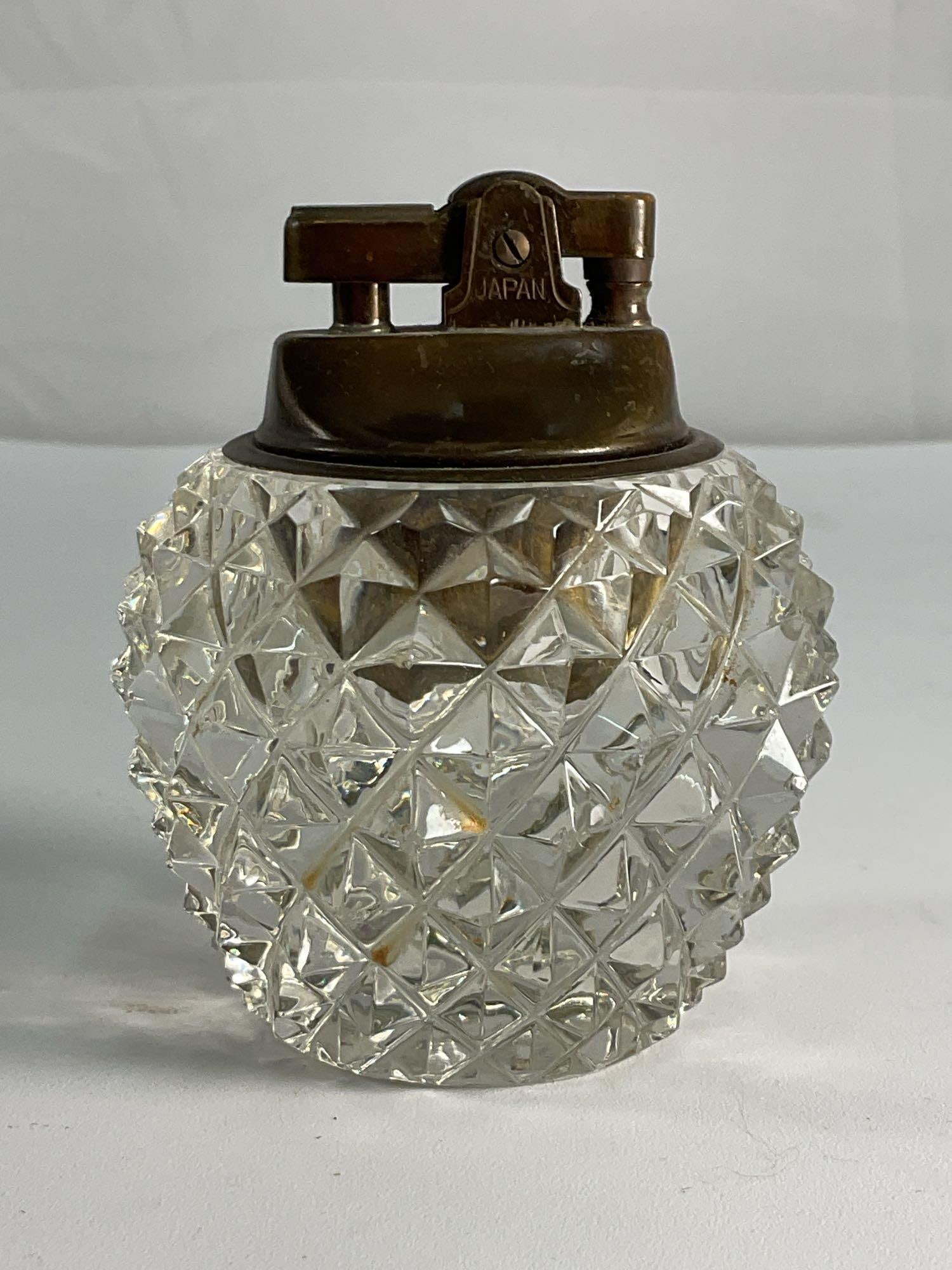 Vintage Cut Glass lighter: A finely crafted vintage cut glass lighter holder with an intricate diamond pattern. The faceted design catches the light beautifully, creating an elegant sparkle. Perfect for enhancing any table sett