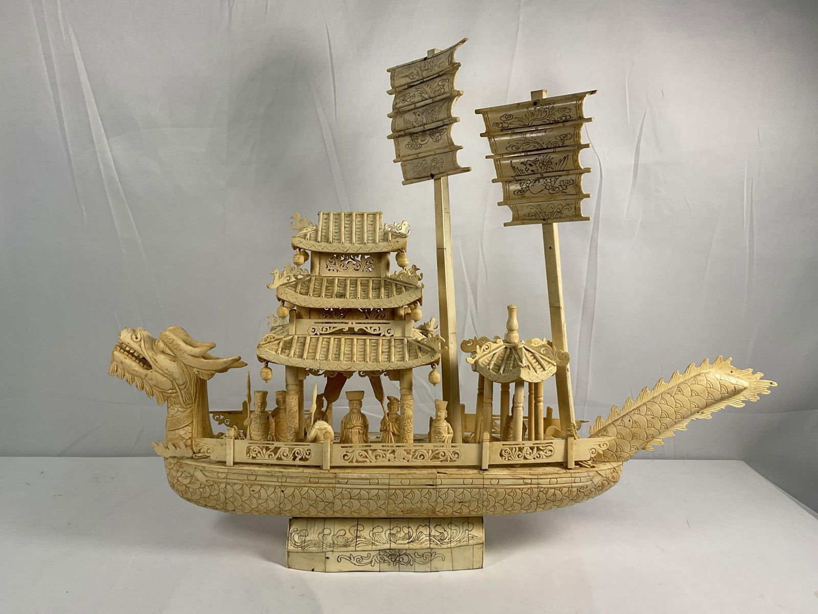 Bone Carving Ship: This is an exquisitely detailed hand-carved bone sculpture depicting a dragon ship, a symbol of prosperity and protection in many East Asian cultures. The piece features ornate craftsmanship with intr