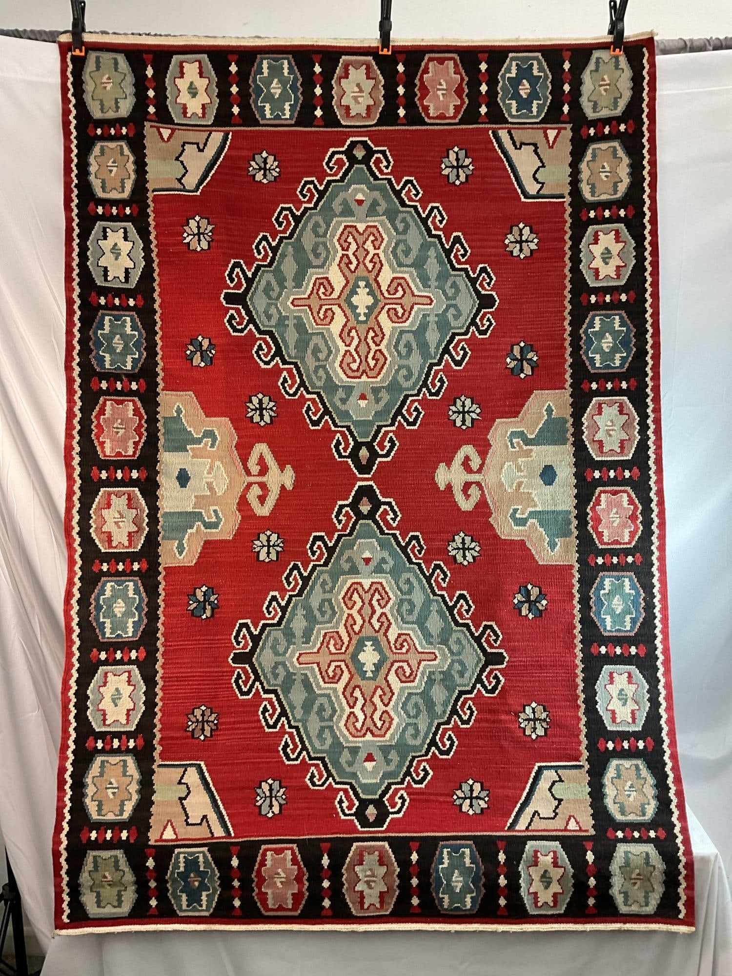 Brand New Mongol Kilim Handwoven Rug: This is a brand-new handwoven Mongol Kilim rug, part of the Mongol Kilim Collection. The rug features a bold geometric design with intricate medallions, a rich red field, and complementary blue, black