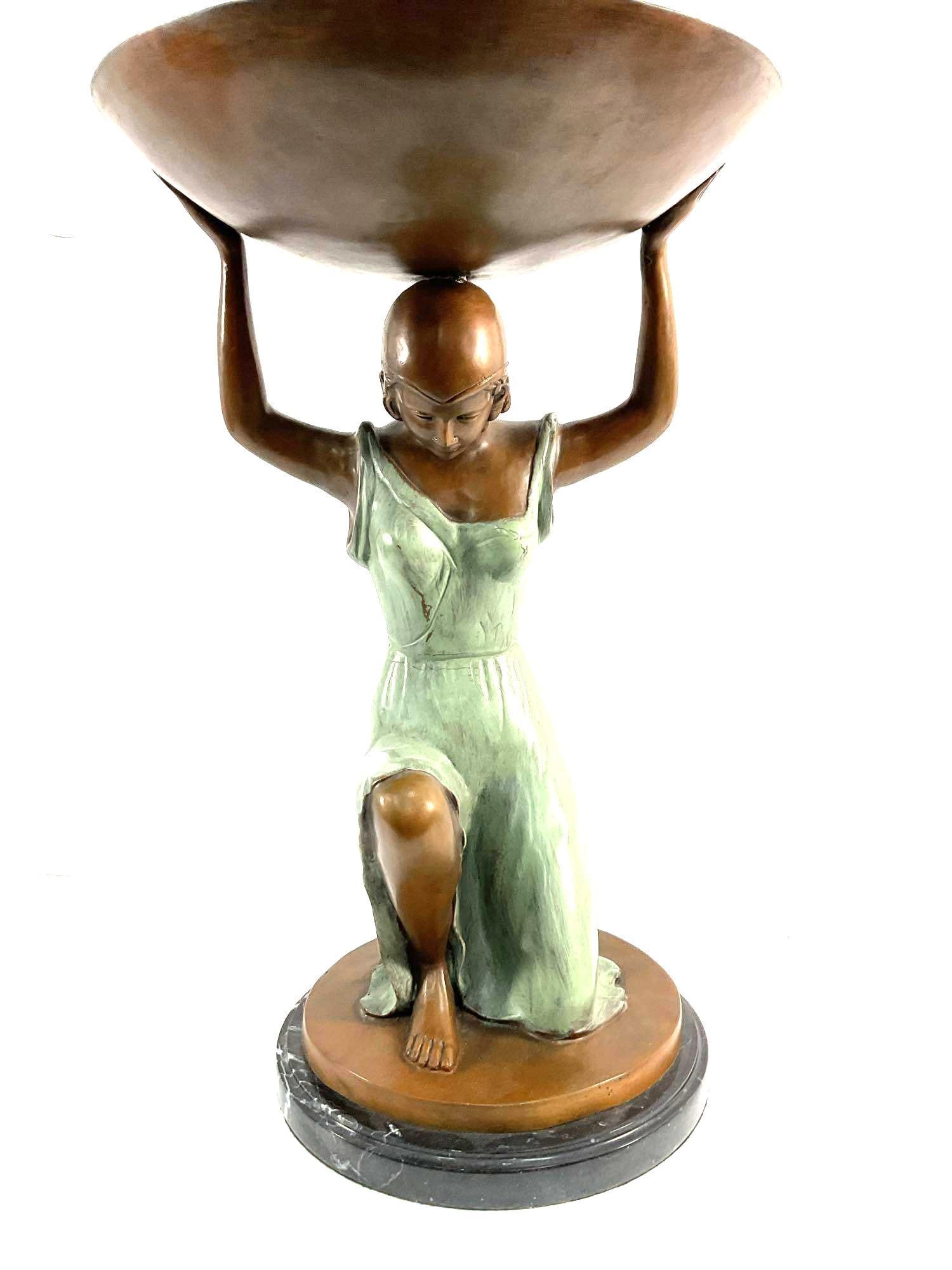 Bronze & Marble Sculpture - Kneeling Woman: This is a bronze and marble sculpture of a kneeling woman in a flowing green dress, gracefully holding a large bowl above her head. The figure is sculpted with delicate features, a serene posture, and
