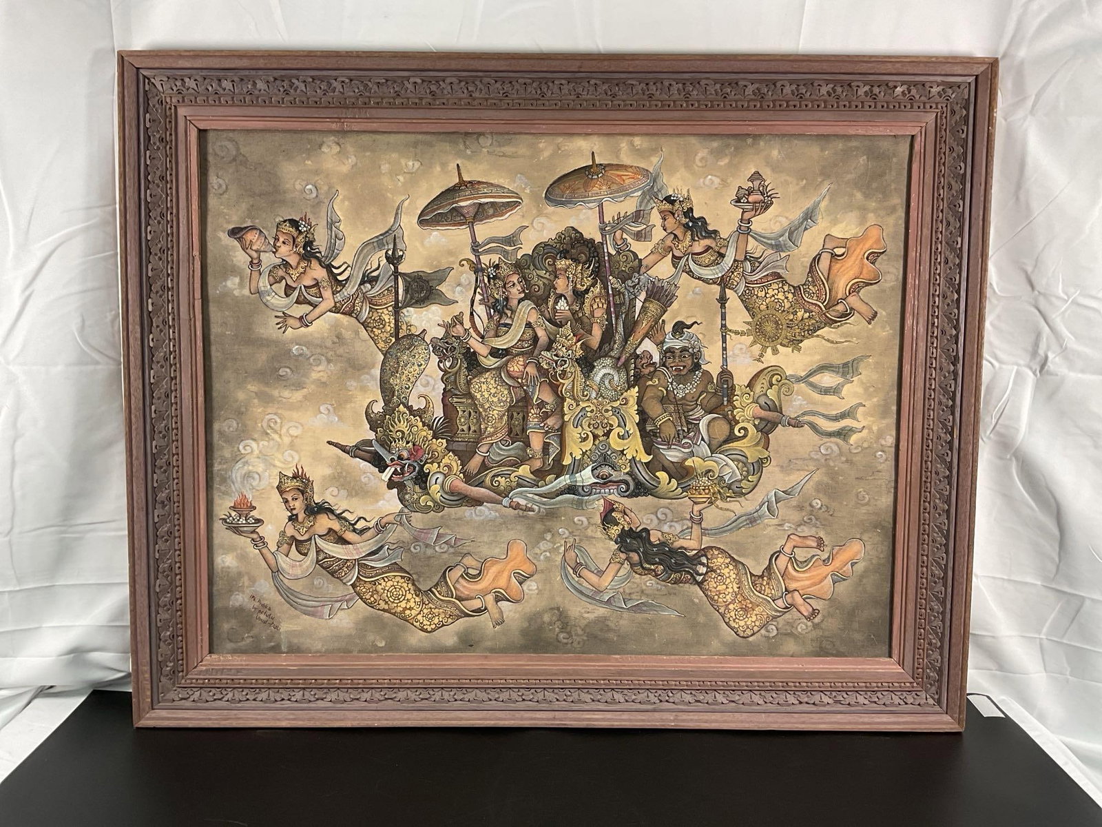 Balinese Oil Painting: This detailed and ornate artwork features a mythological scene with deities, celestial beings, and fantastical creatures, presented in a traditional Asian style. The figures are adorned with intricate