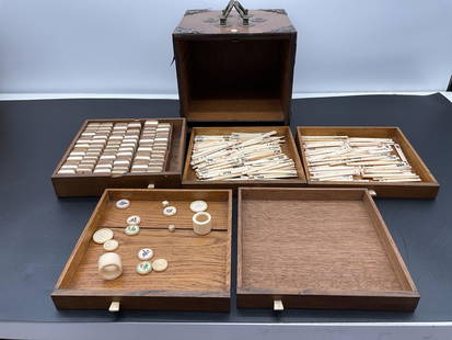 Antique Chinese Mahjong Set in Carved Wood Box: A traditional Chinese mahjong set housed in an ornate wooden cabinet with brass hardware and carved coin motifs on the front and back panels. The box features multiple pull-out drawers containing bone