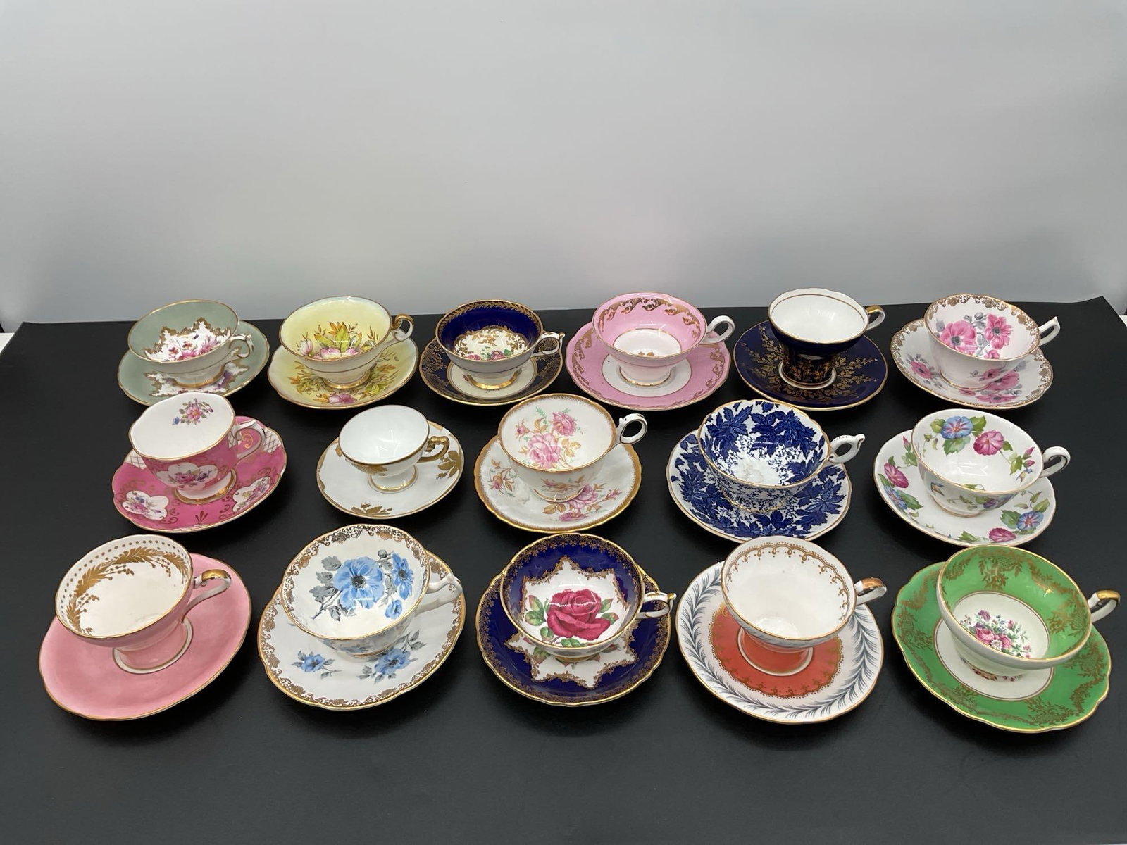 Collection of Assorted Vintage English Teacup and Saucer Duos: This is a curated collection of 14 assorted vintage teacup and saucer sets, each featuring vibrant floral motifs, gilt accents, and colorful glazes. Styles range from soft pastels and bone china flora