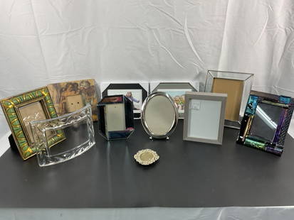 Assorted Picture Frames: This box contains a variety of picture frames, including mirrored, metallic, and wood-finished designs. Some frames feature decorative text such as "Papa" and "Nana," making them