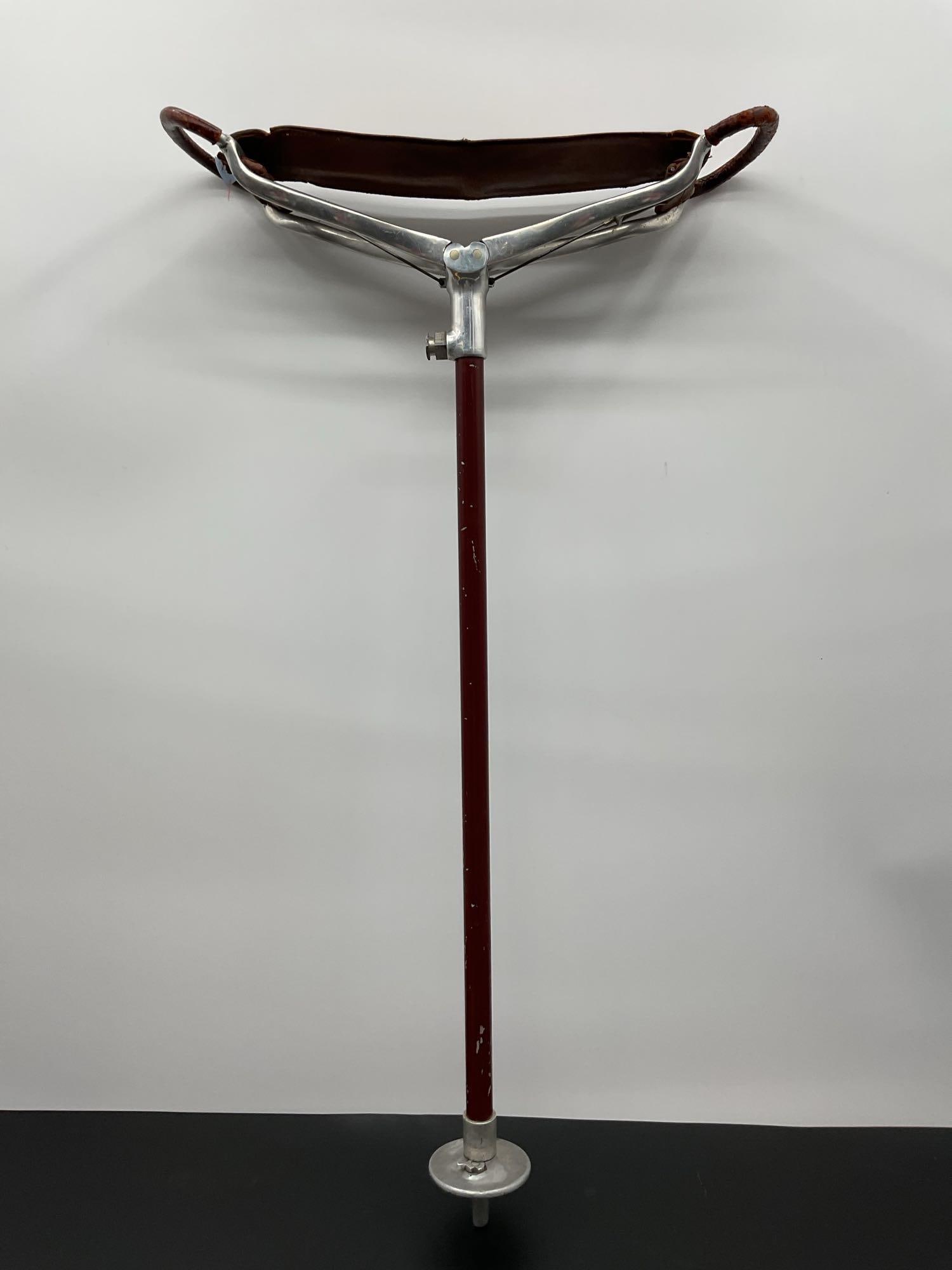 Vintage Leather and Metal Shooting Stick / Portable Seat Cane: This is a vintage combination walking cane and folding seat known as a shooting stick. It features a single metal shaft with a leather sling-style seat and metal handles that fold out to provide a tem