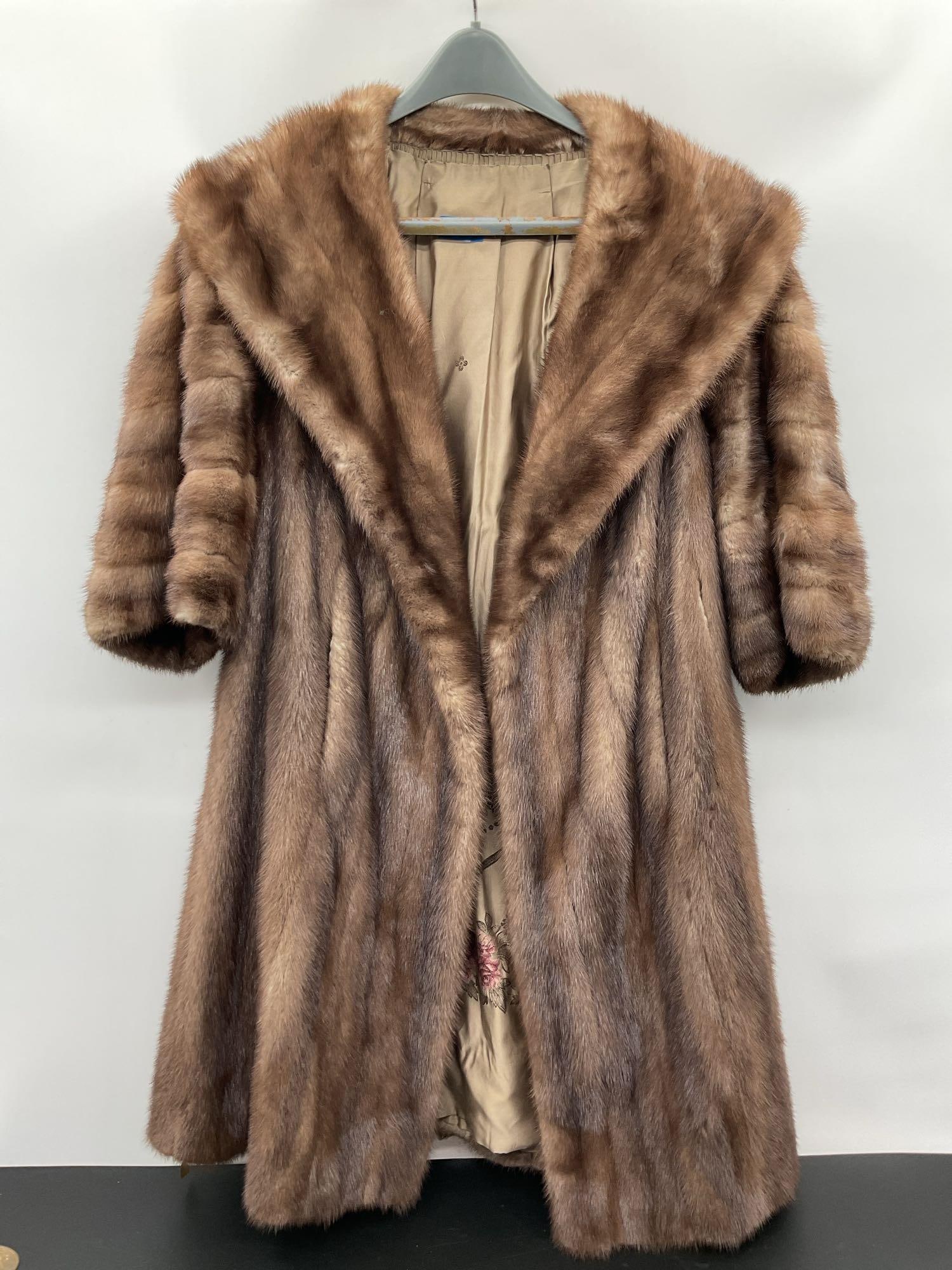 Vintage Dark Mink Fur Cape: This is a mid-century full cape made of dark mink fur, designed to drape over the shoulders and upper body. The rich brown pelts have a natural sheen and are arranged vertically to create a flowing, l